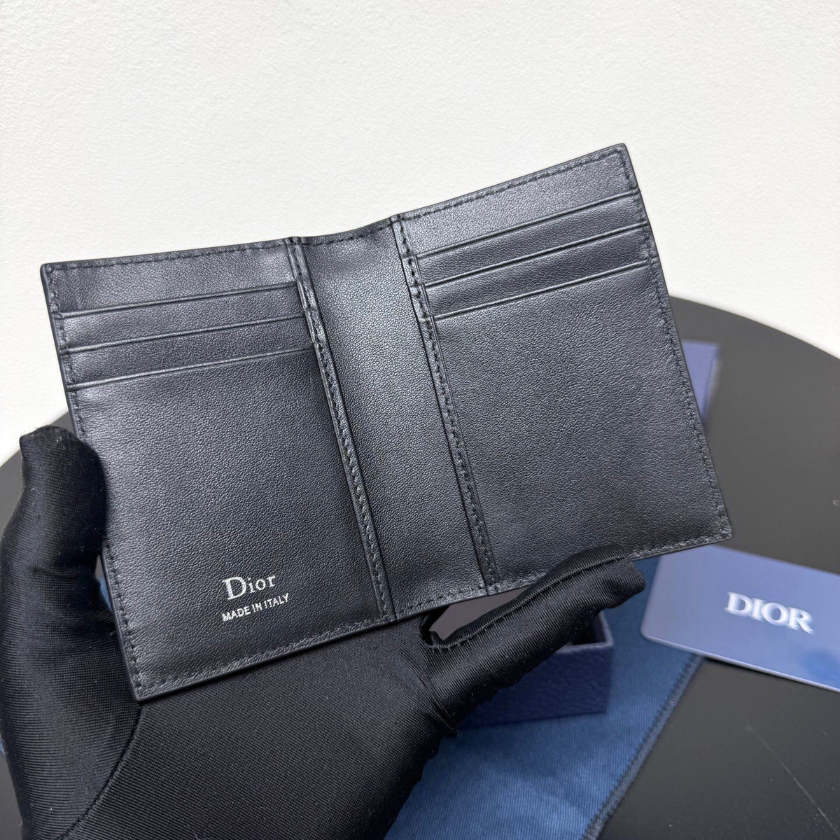 This vertical bifold card holder is elegant and practical. It is crafted from grained cow leather. It is decorated with the CD logo on the front. It has three card slots on each side and two receipt pockets. It is exquisite and elegant. It can be easily