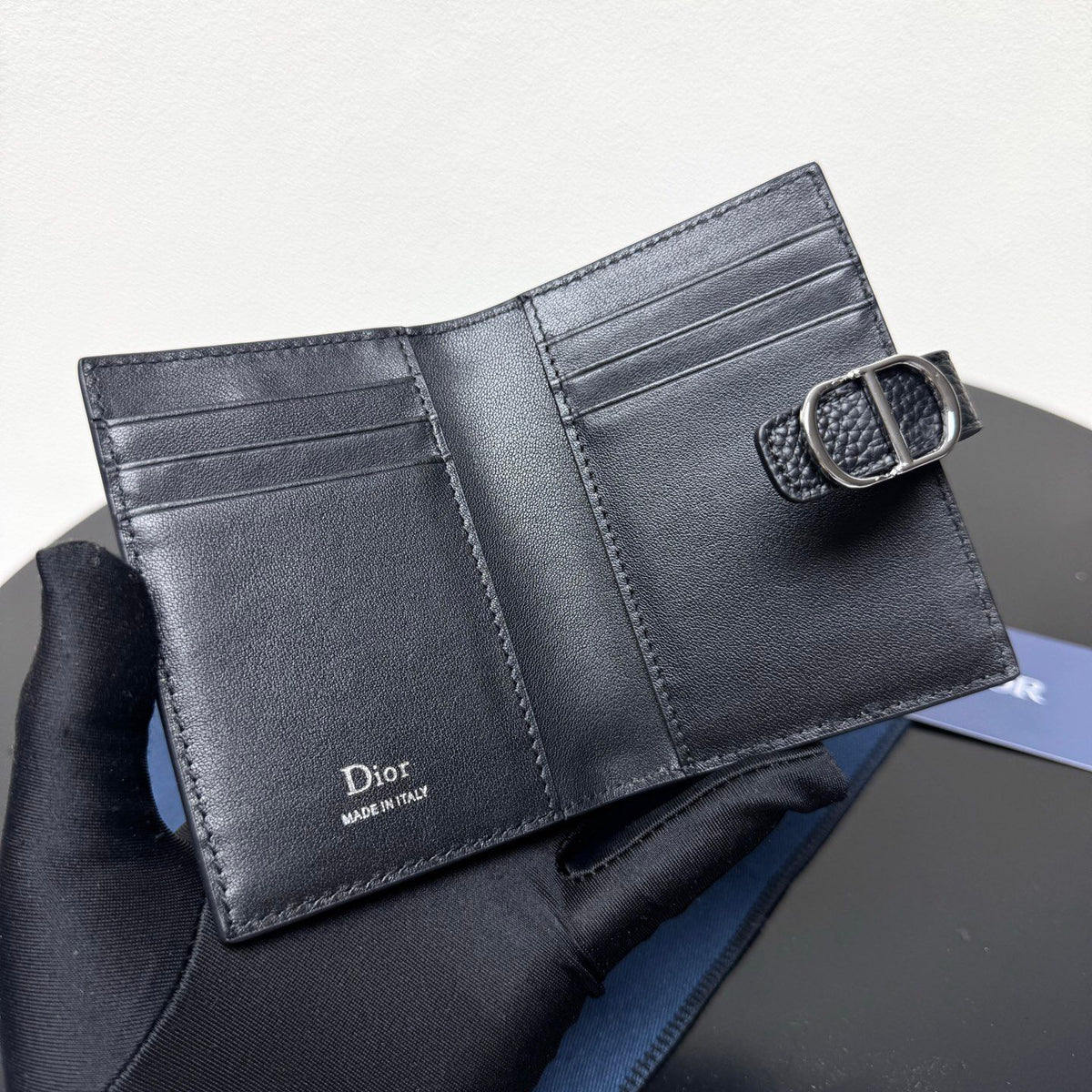 This vertical bifold card holder is elegant and practical. It is crafted from grained cow leather. It is decorated with the CD logo on the front. It has three card slots on each side and two receipt pockets. It is exquisite and elegant. It can be easily