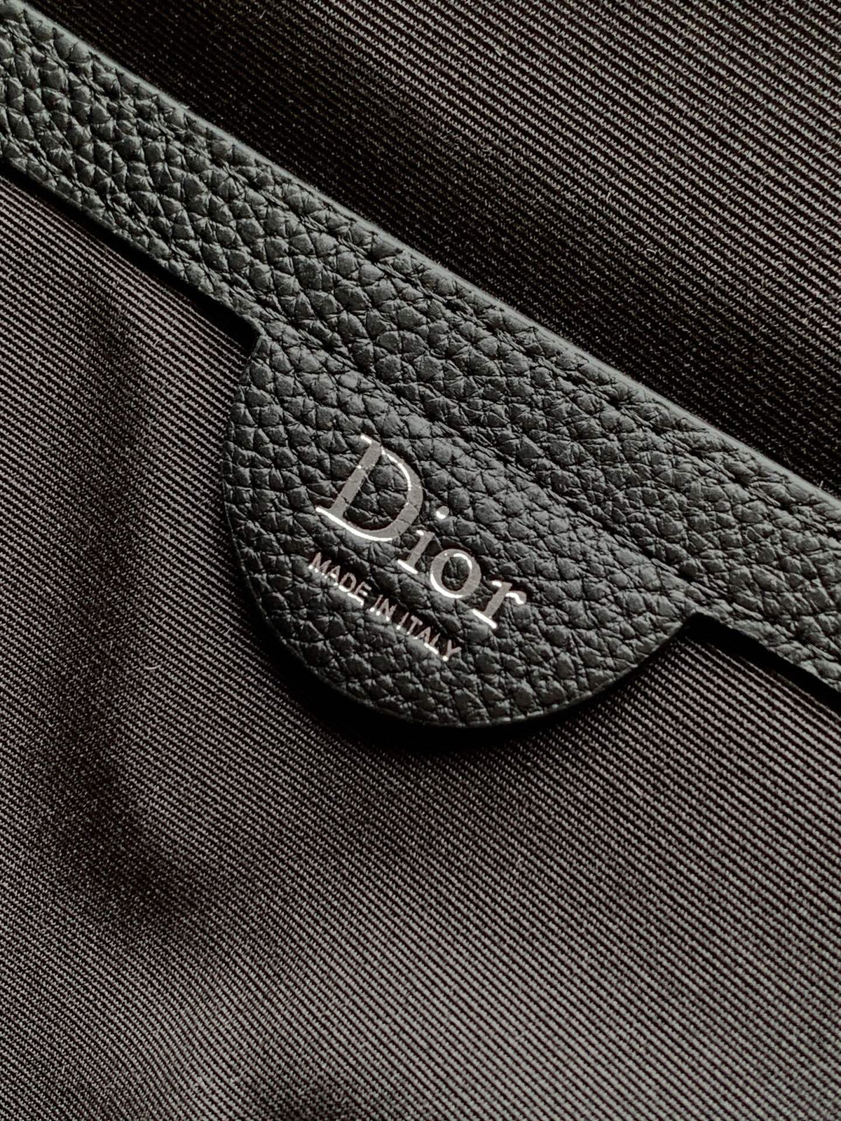 The Heritage Saddle Flap Backpack features a sleek, original design that accentuates your saddle style. Crafted from black Oblique printed fabric, accented with tonal grained calf leather details for added style. A spacious compartment under the saddle