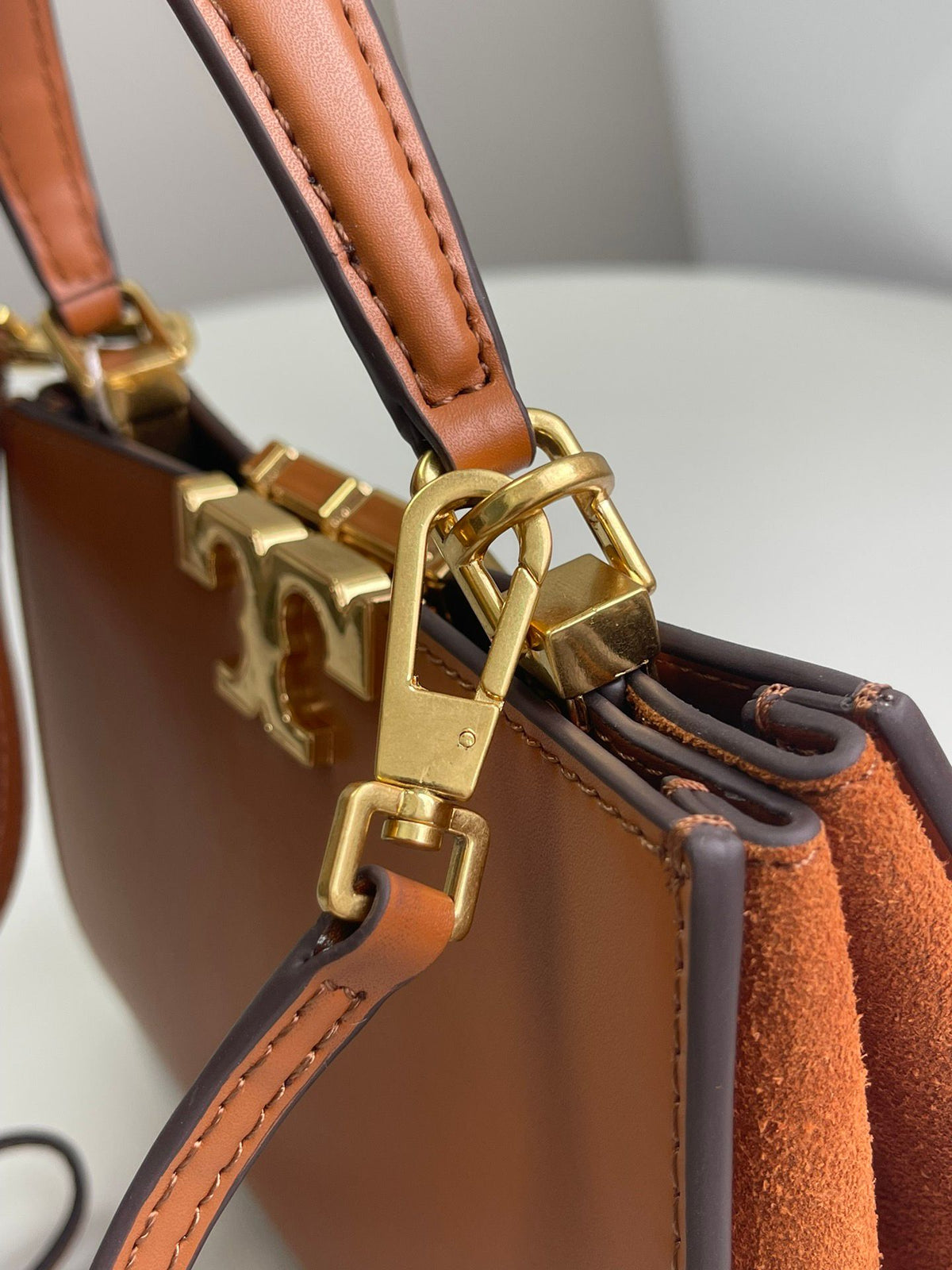 Number 086, TORY BURCH. New Eleanor leather handbag with exquisite suede trim. The bag has a clean and crisp body, and the iconic double T logo is three-dimensional and eye-catching. Exquisite craftsmanship. It can be lifted with a handle or removed