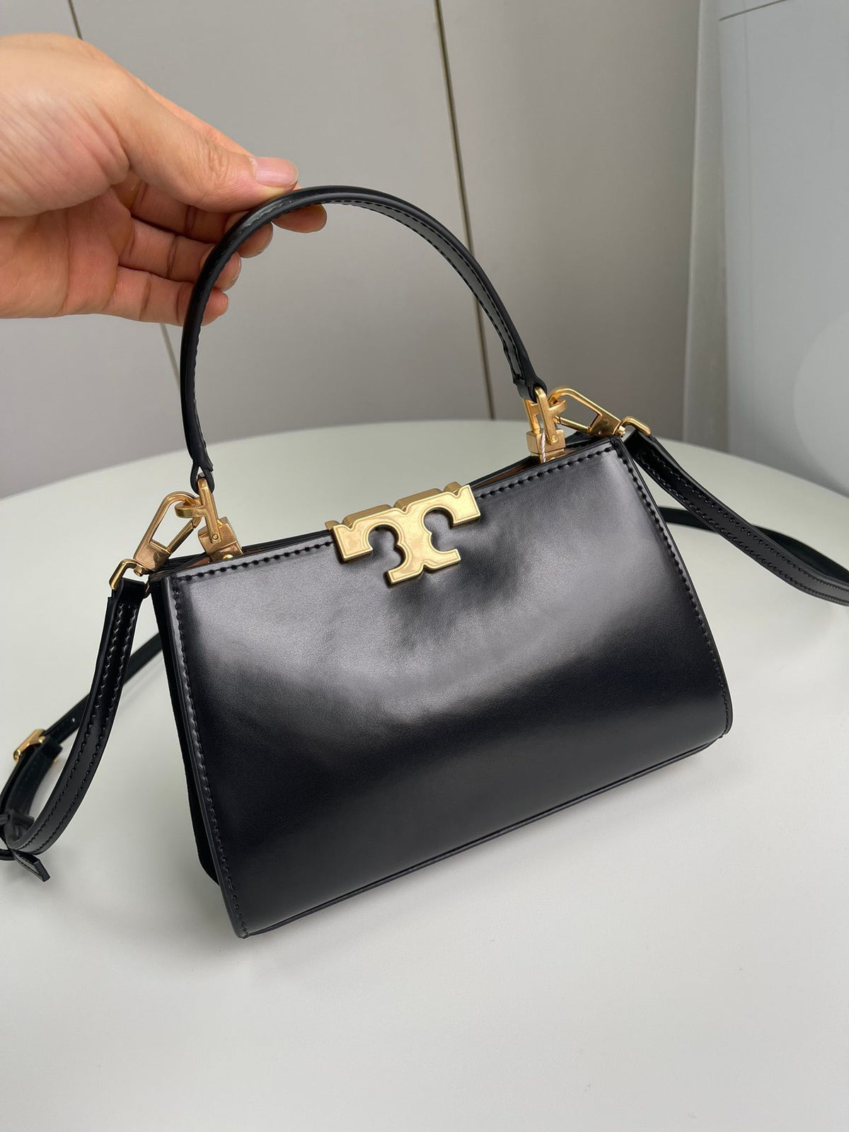 Number 086, TORY BURCH. New Eleanor leather handbag with exquisite suede trim. The bag has a clean and crisp body, and the iconic double T logo is three-dimensional and eye-catching. Exquisite craftsmanship. It can be lifted with a handle or removed