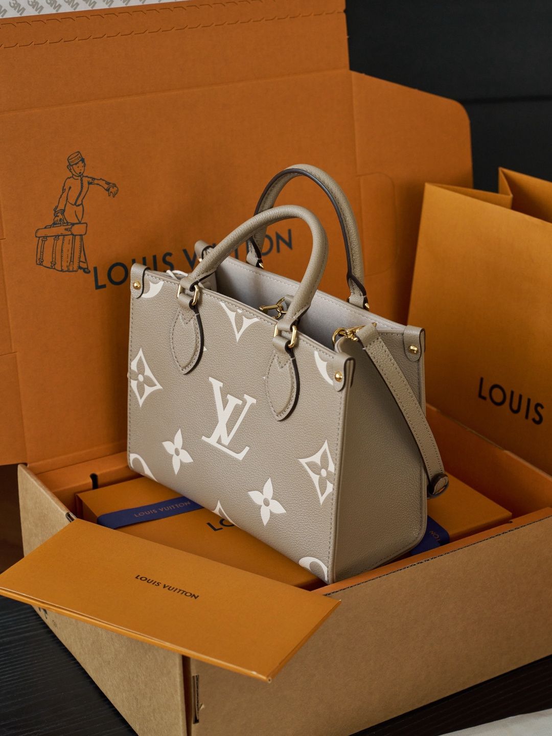 ONTHEGO Small Handbag M45779 This OnTheGo Small Tote Bag draws inspiration from the Sac Plat handbag, which was born in 1968, and incorporates Monogram Empreinte leather with Medium Bicolor Monogram embossing for a slightly smaller size. The original