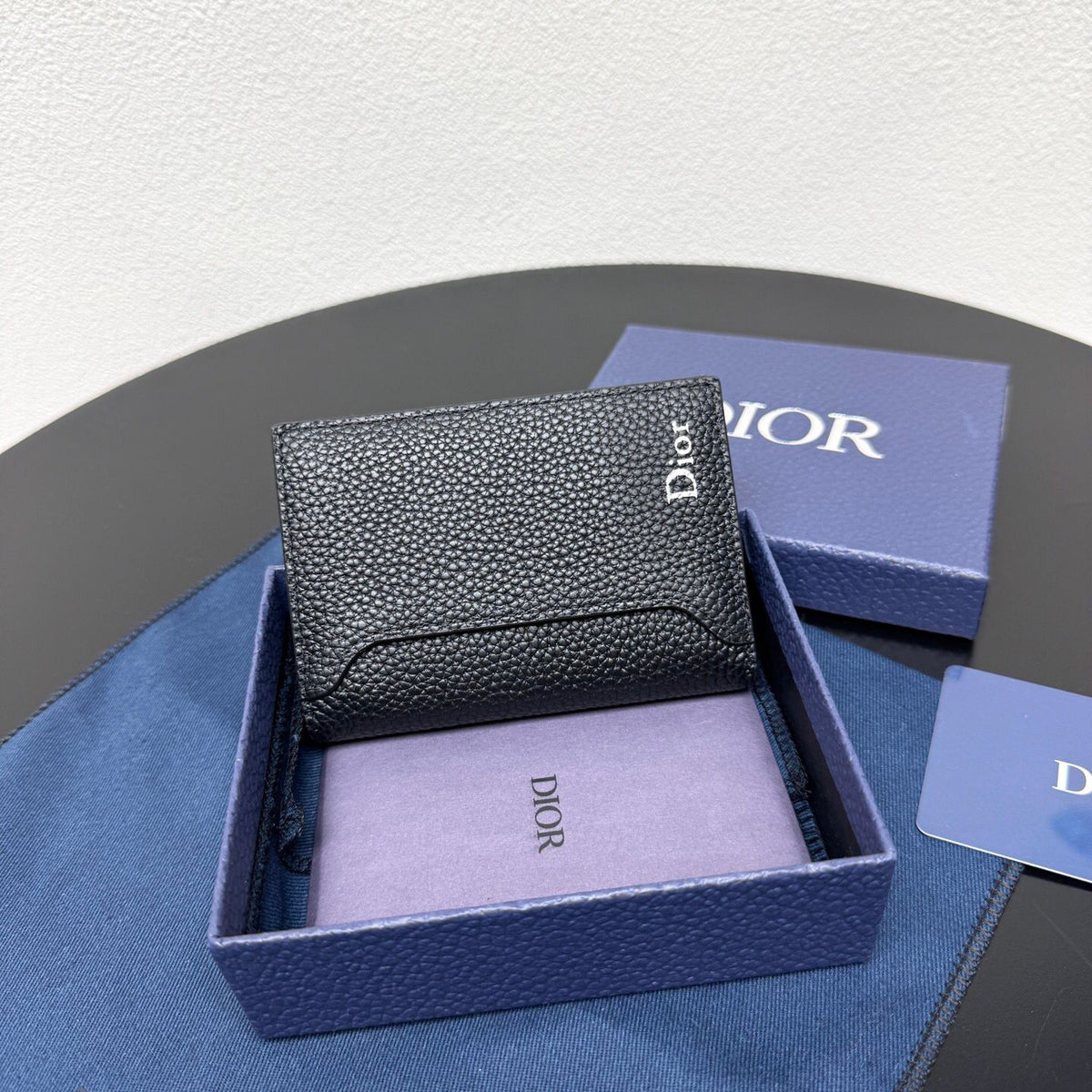 This vertical bifold card holder is elegant and practical. It is crafted from grained cow leather. It is decorated with the CD logo on the front. It has three card slots on each side and two receipt pockets. It is exquisite and elegant. It can be easily