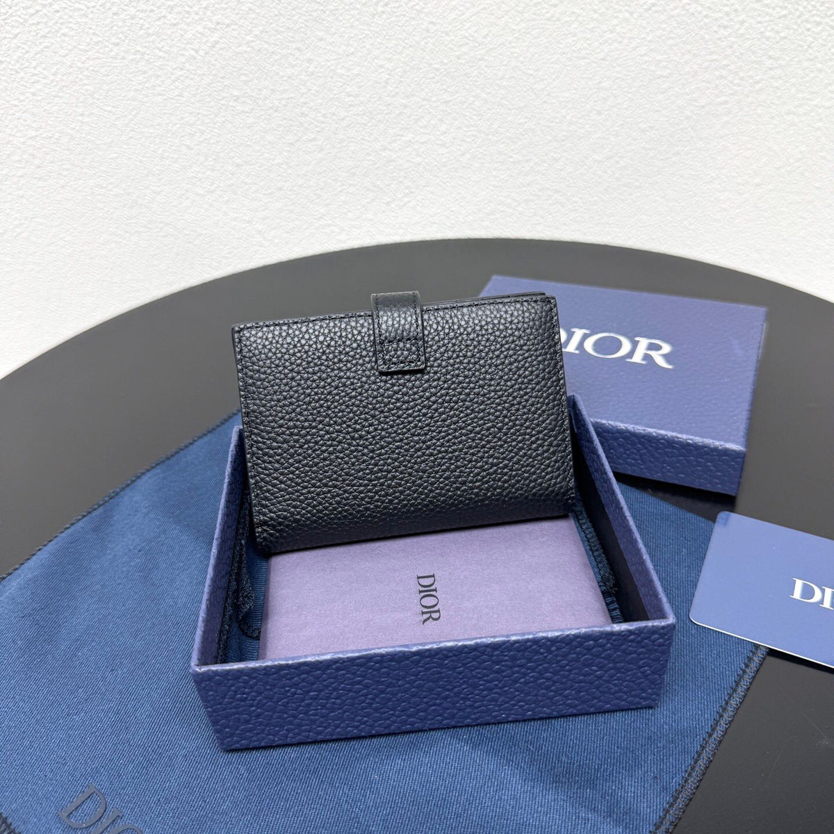 This vertical bifold card holder is elegant and practical. It is crafted from grained cow leather. It is decorated with the CD logo on the front. It has three card slots on each side and two receipt pockets. It is exquisite and elegant. It can be easily