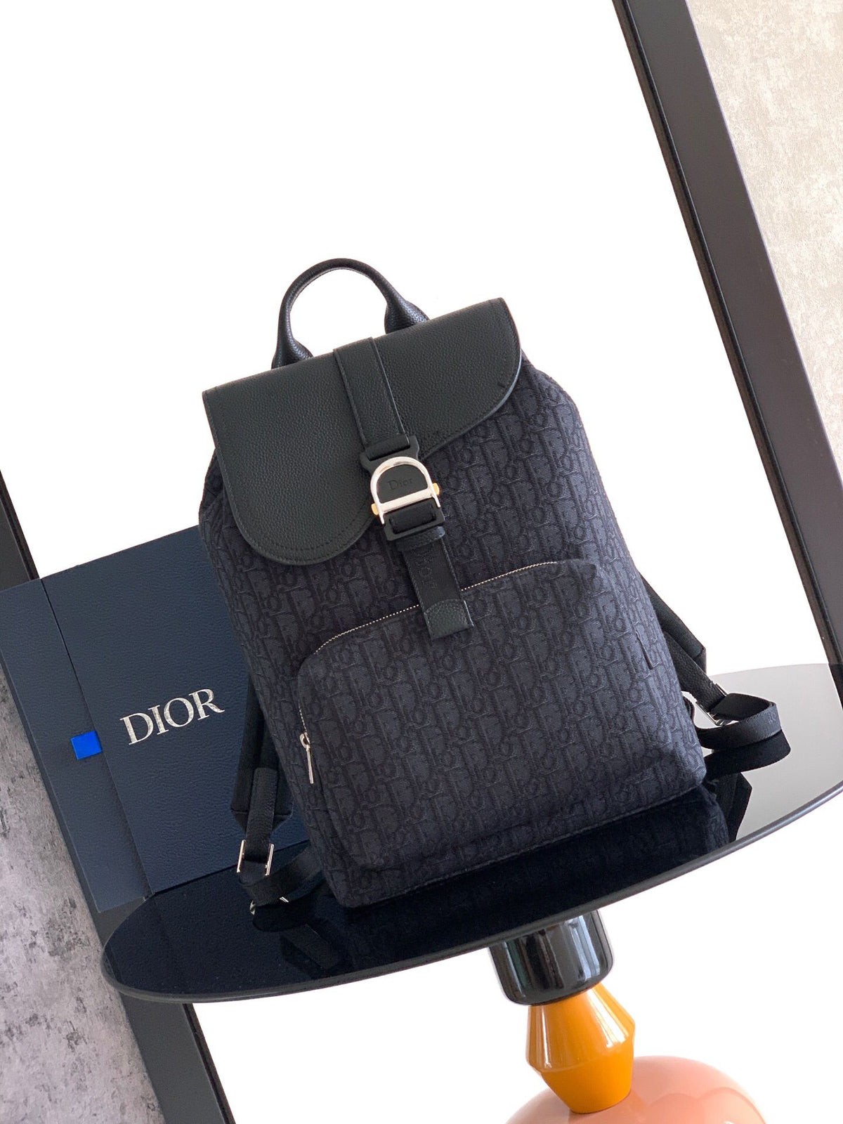 The Heritage Saddle Flap Backpack features a sleek, original design that accentuates your saddle style. Crafted from black Oblique printed fabric, accented with tonal grained calf leather details for added style. A spacious compartment under the saddle