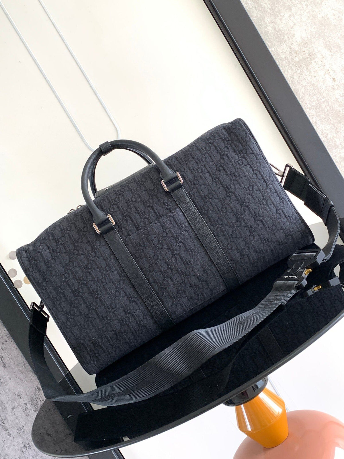 This Dio Lingot 50 handbag is new this season. Practical and elegant, unique. Crafted from black Oblique jacquard fabric. With black grained calfskin leather details to enhance the style. Decorated with DIO logo on the front. Zippered compartment with