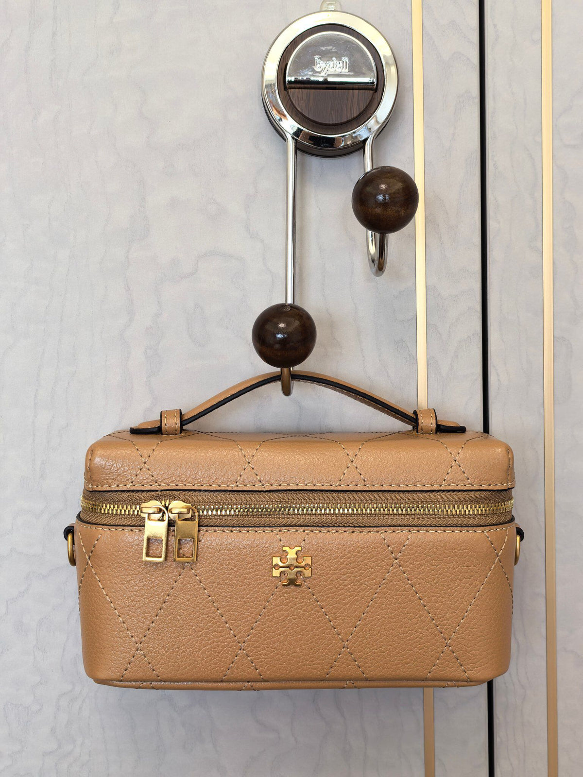 Apricot TORY BURCH KIRA DIAMOND QUILT CHARM EAST-WEST VANITY CASE diamond box bag is made of quilted cowhide with iconic double T metal logo, simple yet recognizable. The chain shoulder strap can be carried diagonally or carried on one shoulder, flexible