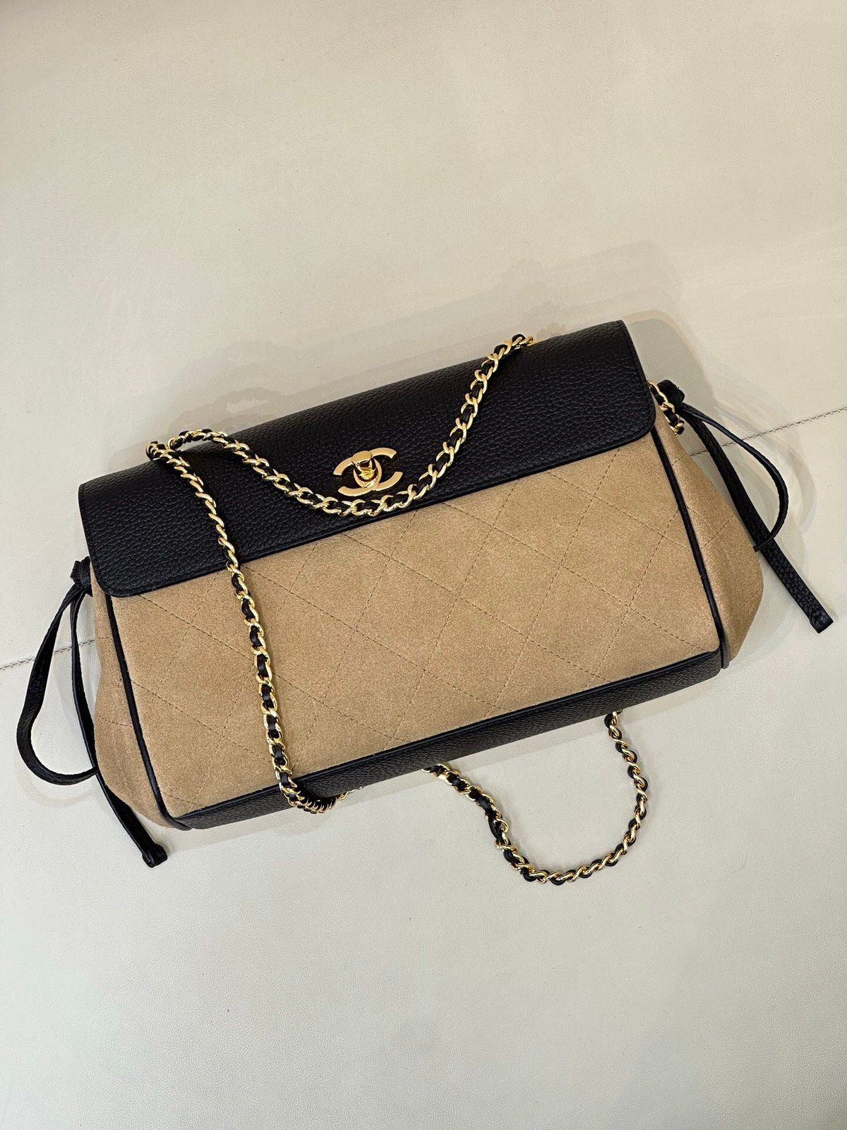 The main body of the apricot bag is made of fine khaki suede. The surface layer has even and soft fluff, with a matte matte texture. It has a retro and old atmosphere. The upper cover is spliced with black grained cowhide. The collision of soft and