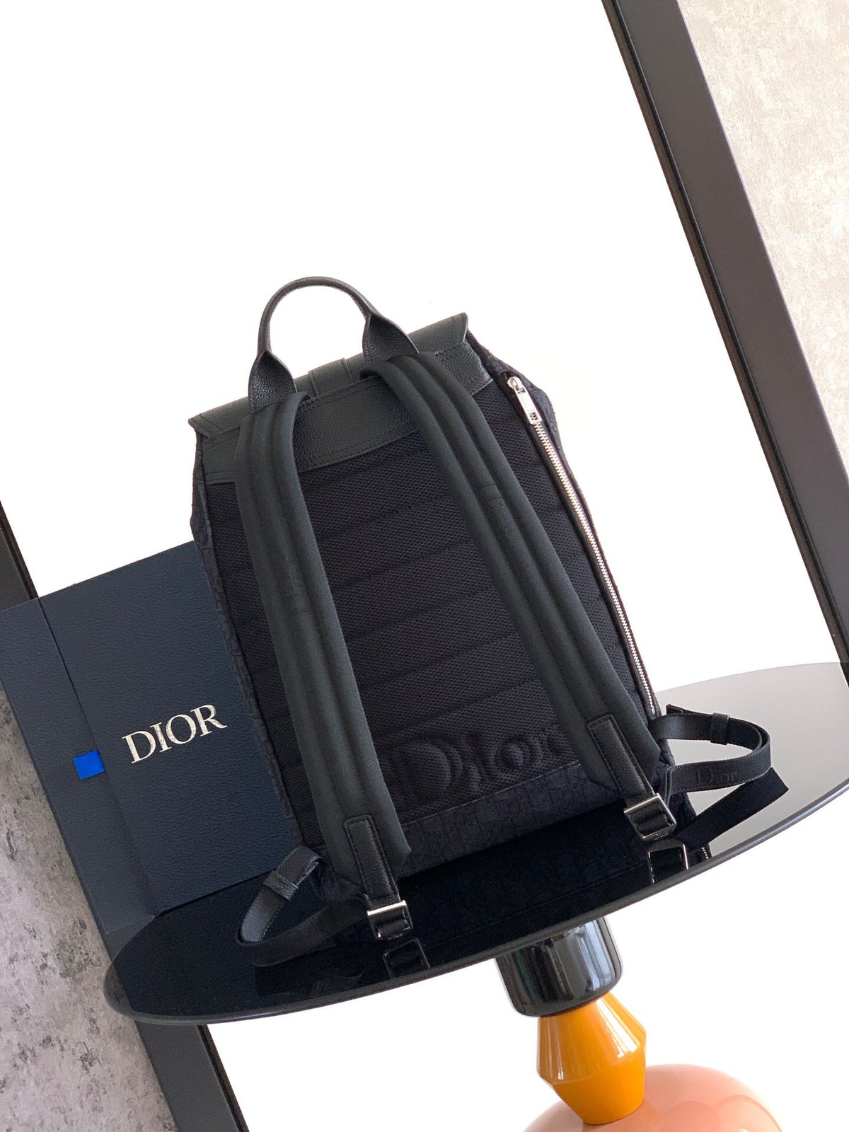 The Heritage Saddle Flap Backpack features a sleek, original design that accentuates your saddle style. Crafted from black Oblique printed fabric, accented with tonal grained calf leather details for added style. A spacious compartment under the saddle