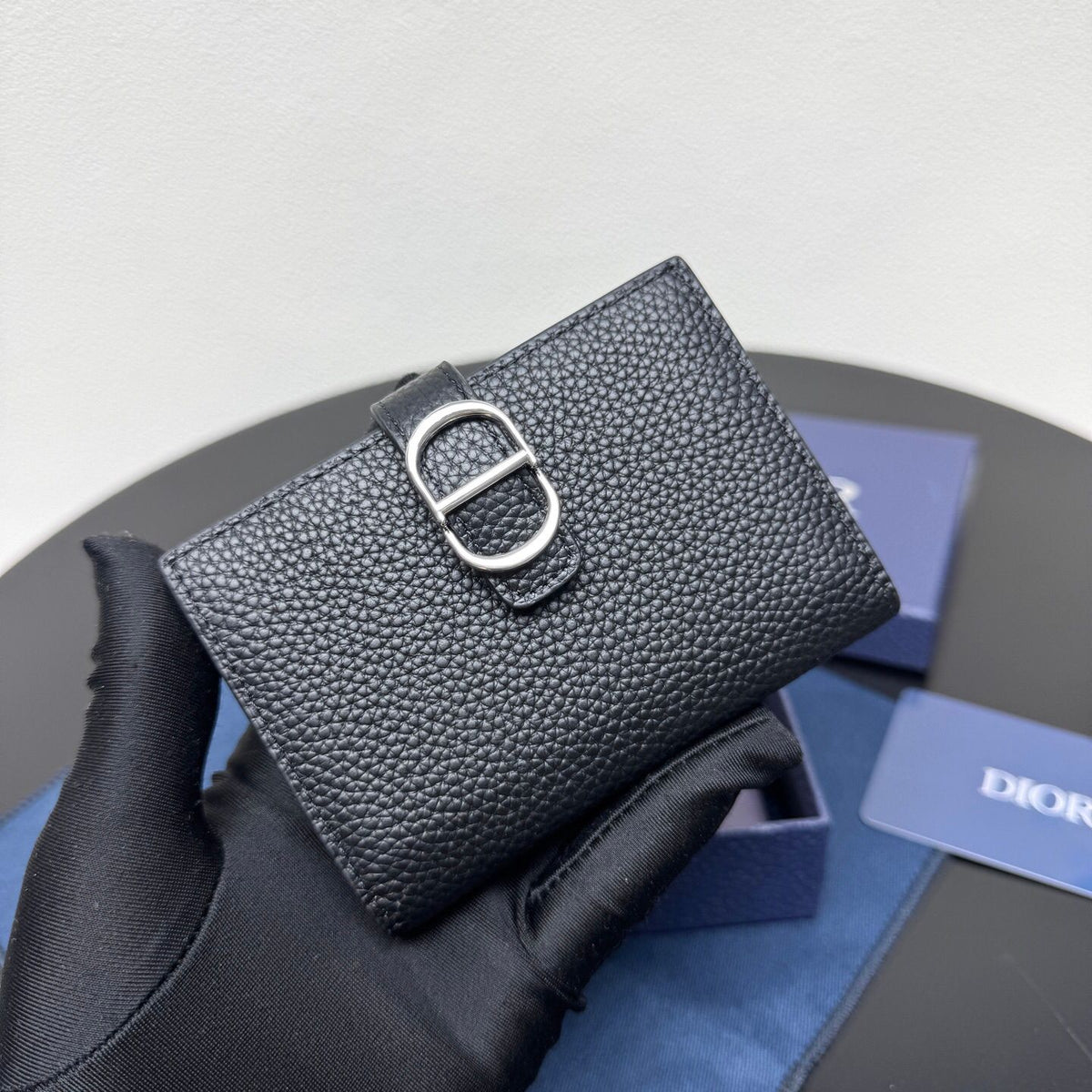 This vertical bifold card holder is elegant and practical. It is crafted from grained cow leather. It is decorated with the CD logo on the front. It has three card slots on each side and two receipt pockets. It is exquisite and elegant. It can be easily