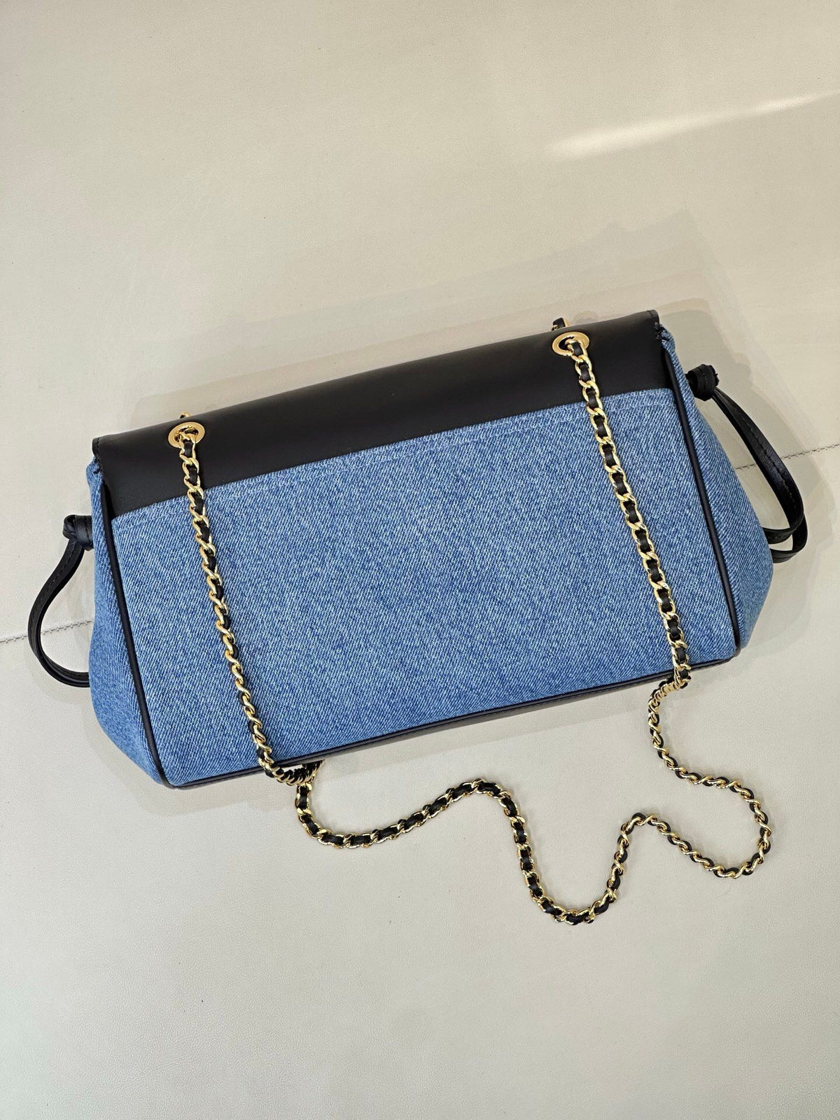 Denim blue. The main body is stone-washed blue denim fabric. The texture of the fabric is clear. It is a natural and soft denim blue. It is not too bright blue. The upper cover is spliced with black smooth first-layer cowhide. The tough denim and the