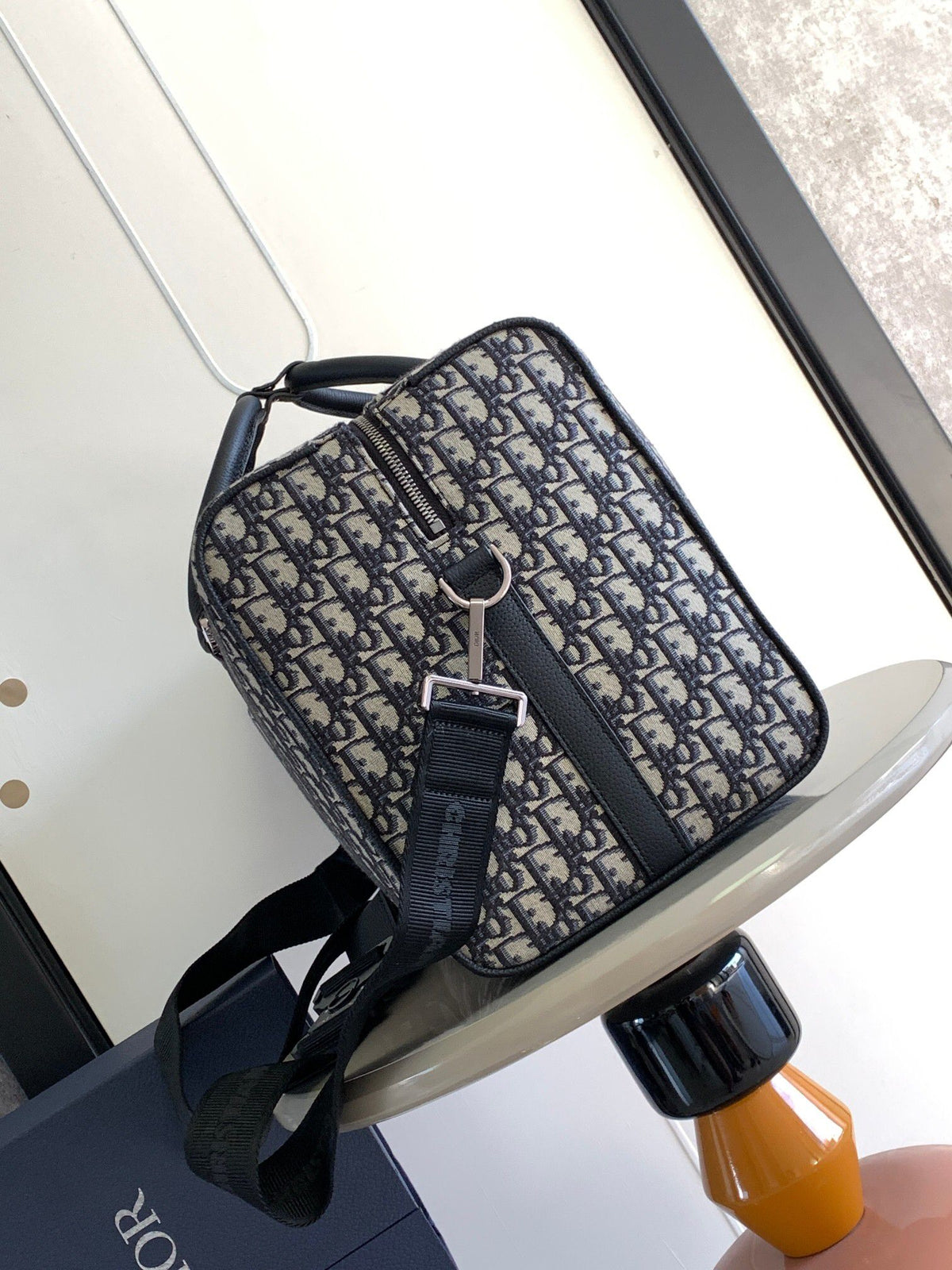 This Dio Lingot 50 handbag is new for this season. Practical yet elegant, it is unique. Crafted from beige and black Oblique printed fabric. Enhanced with black grained calfskin leather details. DIO logo on the front. Zippered compartment with saddle