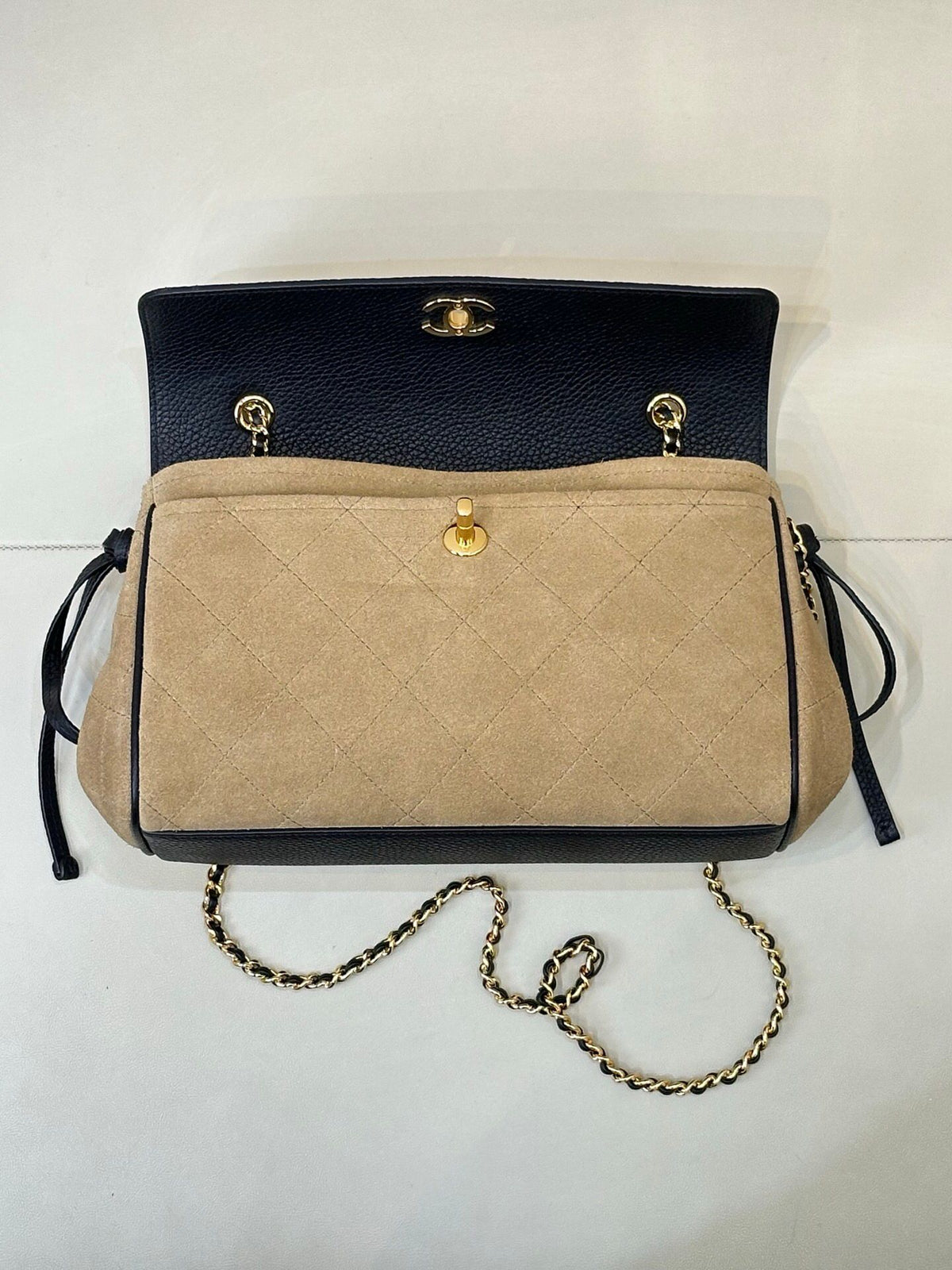 The main body of the apricot bag is made of fine khaki suede. The surface layer has even and soft fluff, with a matte matte texture. It has a retro and old atmosphere. The upper cover is spliced with black grained cowhide. The collision of soft and