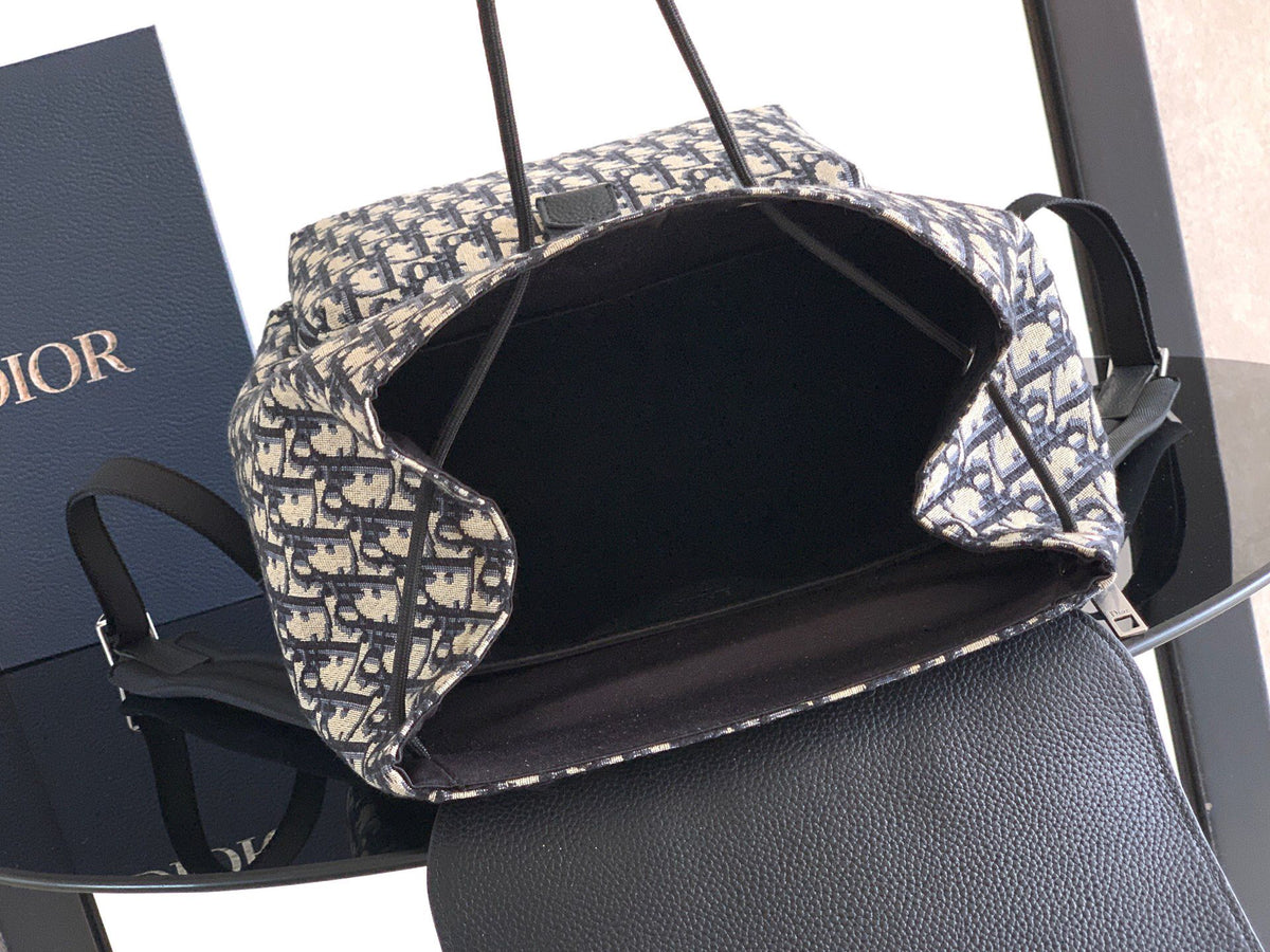 The Heritage Saddle Flap Backpack features a stylish original design that accentuates your saddle style. Crafted from beige and black Oblique print fabric with black grained calf leather details. A spacious compartment under the saddle flap embellished