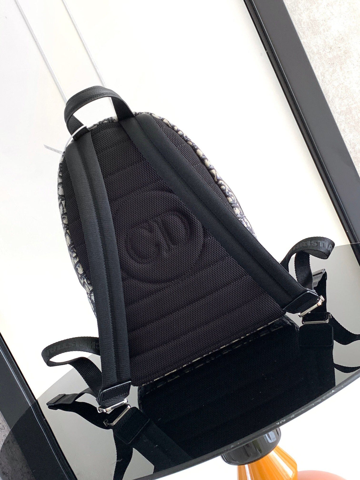 Under the small black lettering. This Rider backpack has a simple silhouette. The classic collegiate style is full of energy. Inspired by the Dior men's collection. Reinterpreted in beige and blue jacquard fabrics. Oblique print throughout. Continuing