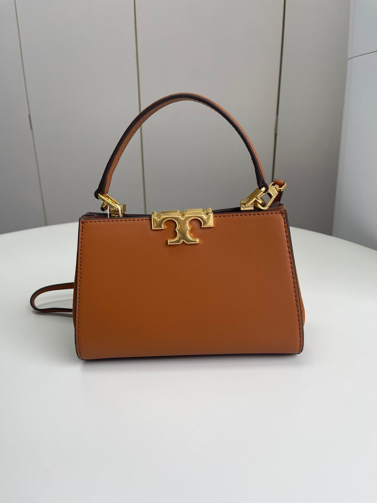 Number 086, TORY BURCH. New Eleanor leather handbag with exquisite suede trim. The bag has a clean and crisp body, and the iconic double T logo is three-dimensional and eye-catching. Exquisite craftsmanship. It can be lifted with a handle or removed