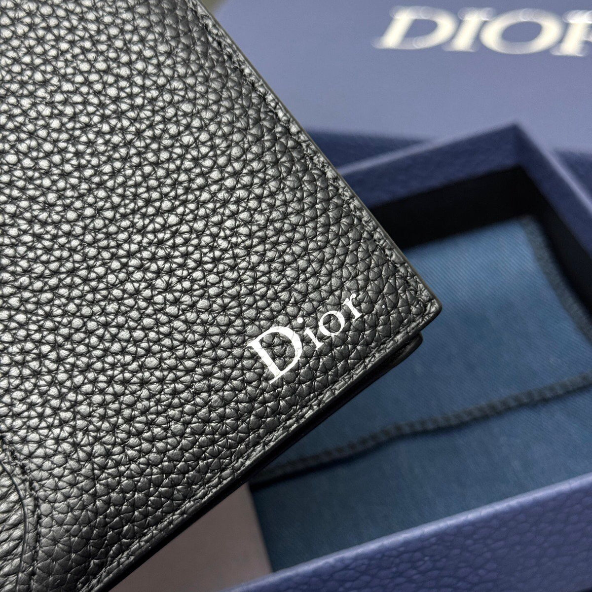 Stylish and functional, this vertical bi-fold wallet is crafted from black grained cow leather. Vertical bi-fold design. CD logo on front for added style. Features five cash compartments, 16 card slots and a zippered coin compartment. Long vertical design