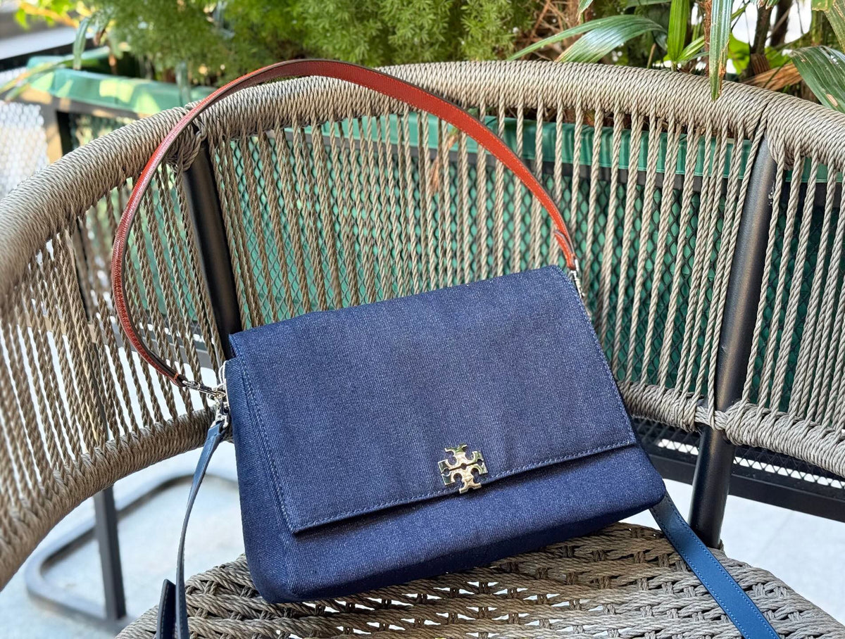 Denim TORY BURCH CHARLE DRNIM SHOULDER BAG denim underarm bag with deep blue denim and contrasting caviar patterned shoulder straps, simple yet textured. The front double T metal logo is highly recognizable, and the underarm back or single shoulder crossb