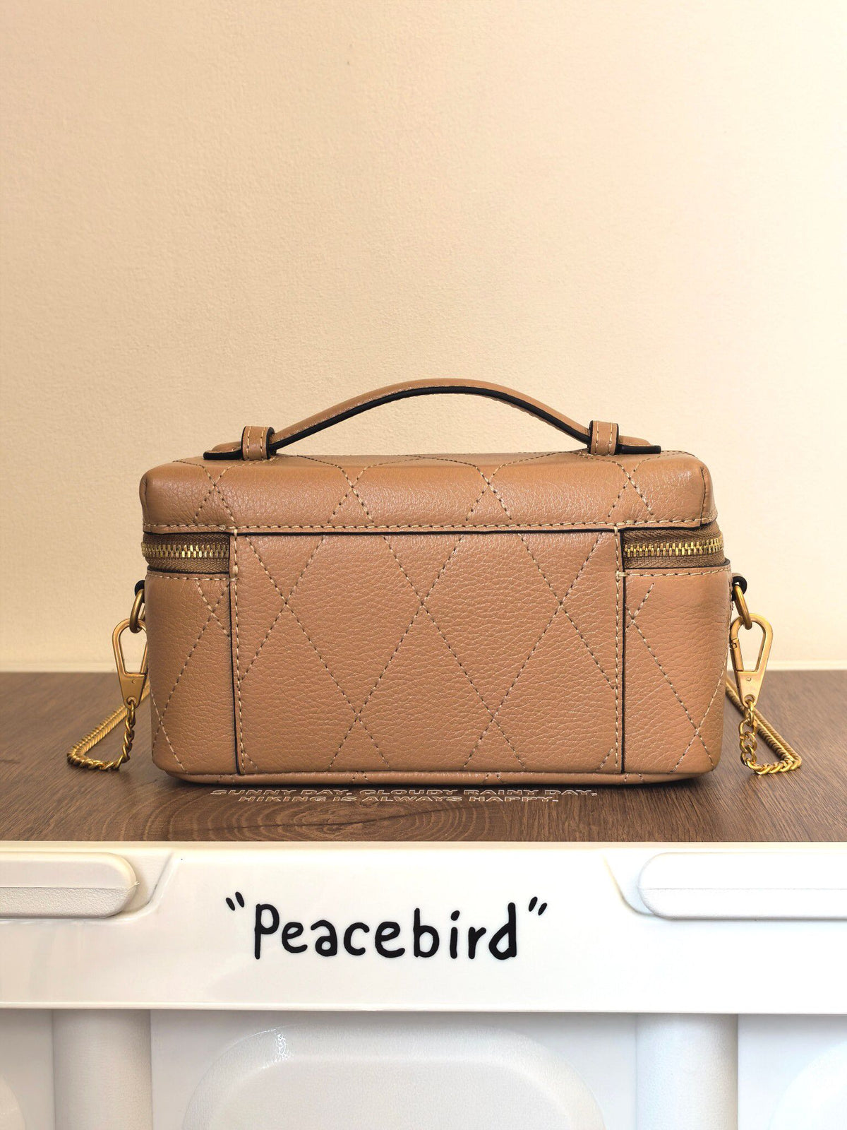 Apricot TORY BURCH KIRA DIAMOND QUILT CHARM EAST-WEST VANITY CASE diamond box bag is made of quilted cowhide with iconic double T metal logo, simple yet recognizable. The chain shoulder strap can be carried diagonally or carried on one shoulder, flexible