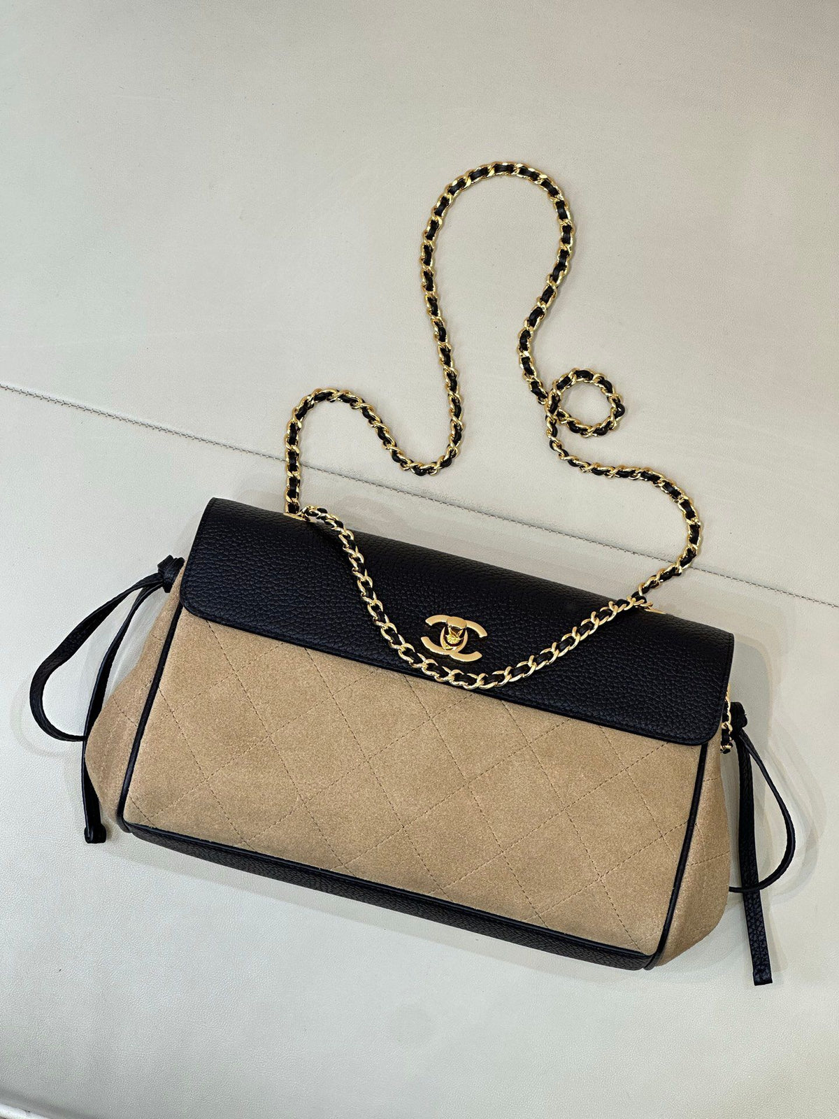 The main body of the apricot bag is made of fine khaki suede. The surface layer has even and soft fluff, with a matte matte texture. It has a retro and old atmosphere. The upper cover is spliced with black grained cowhide. The collision of soft and