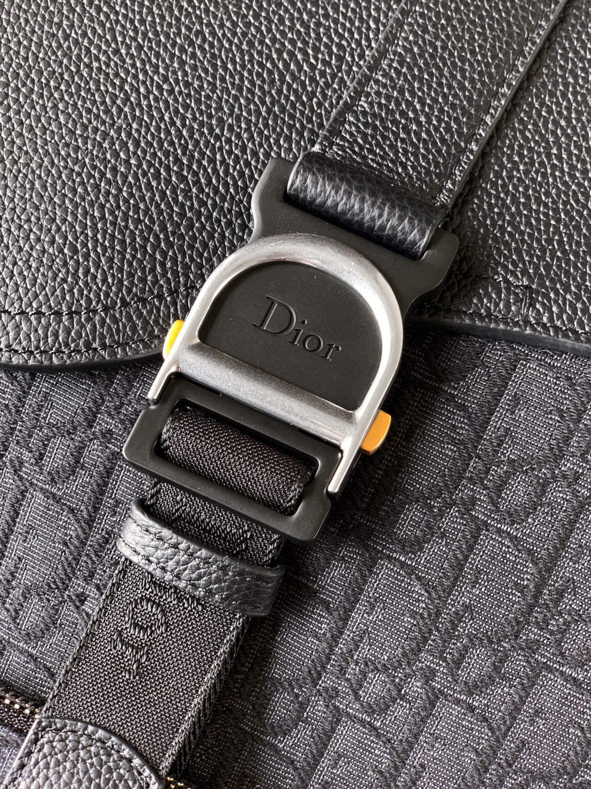 The Heritage Saddle Flap Backpack features a sleek, original design that accentuates your saddle style. Crafted from black Oblique printed fabric, accented with tonal grained calf leather details for added style. A spacious compartment under the saddle