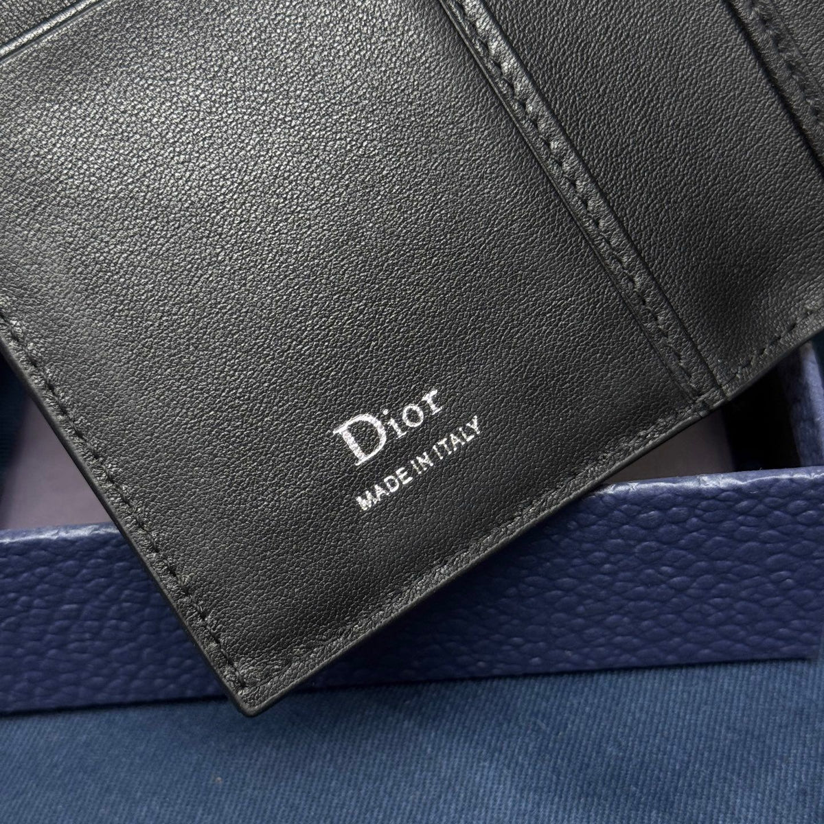 This vertical bifold card holder is elegant and practical. It is crafted from grained cow leather. It is decorated with the CD logo on the front. It has three card slots on each side and two receipt pockets. It is exquisite and elegant. It can be easily