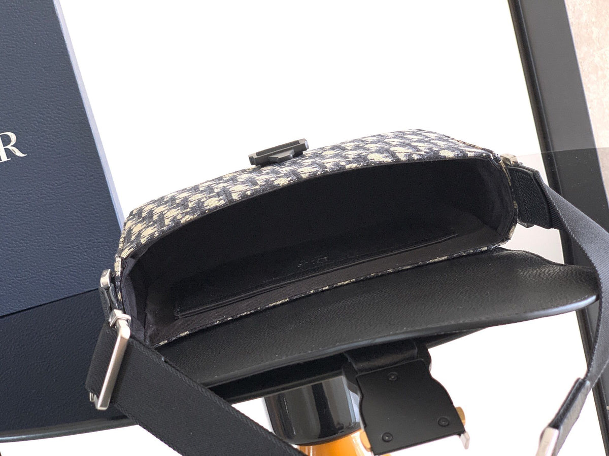 The Heritage Saddle Flap Messenger Bag is sophisticated and stylish with a distinctive style. Combining Oblique printed fabric with grained calfskin, it has an elegant saddle flap and is embellished with a Heritage buckle. A hallmark of classic craftsmans