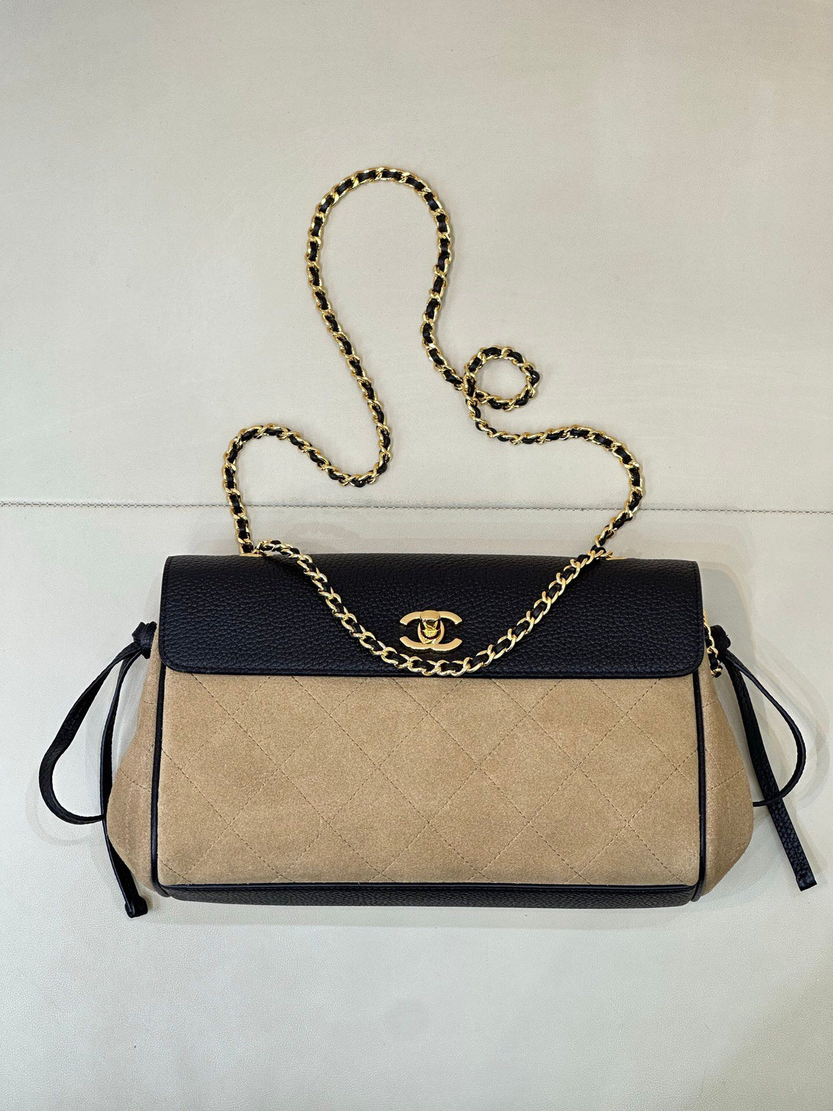 The main body of the apricot bag is made of fine khaki suede. The surface layer has even and soft fluff, with a matte matte texture. It has a retro and old atmosphere. The upper cover is spliced with black grained cowhide. The collision of soft and