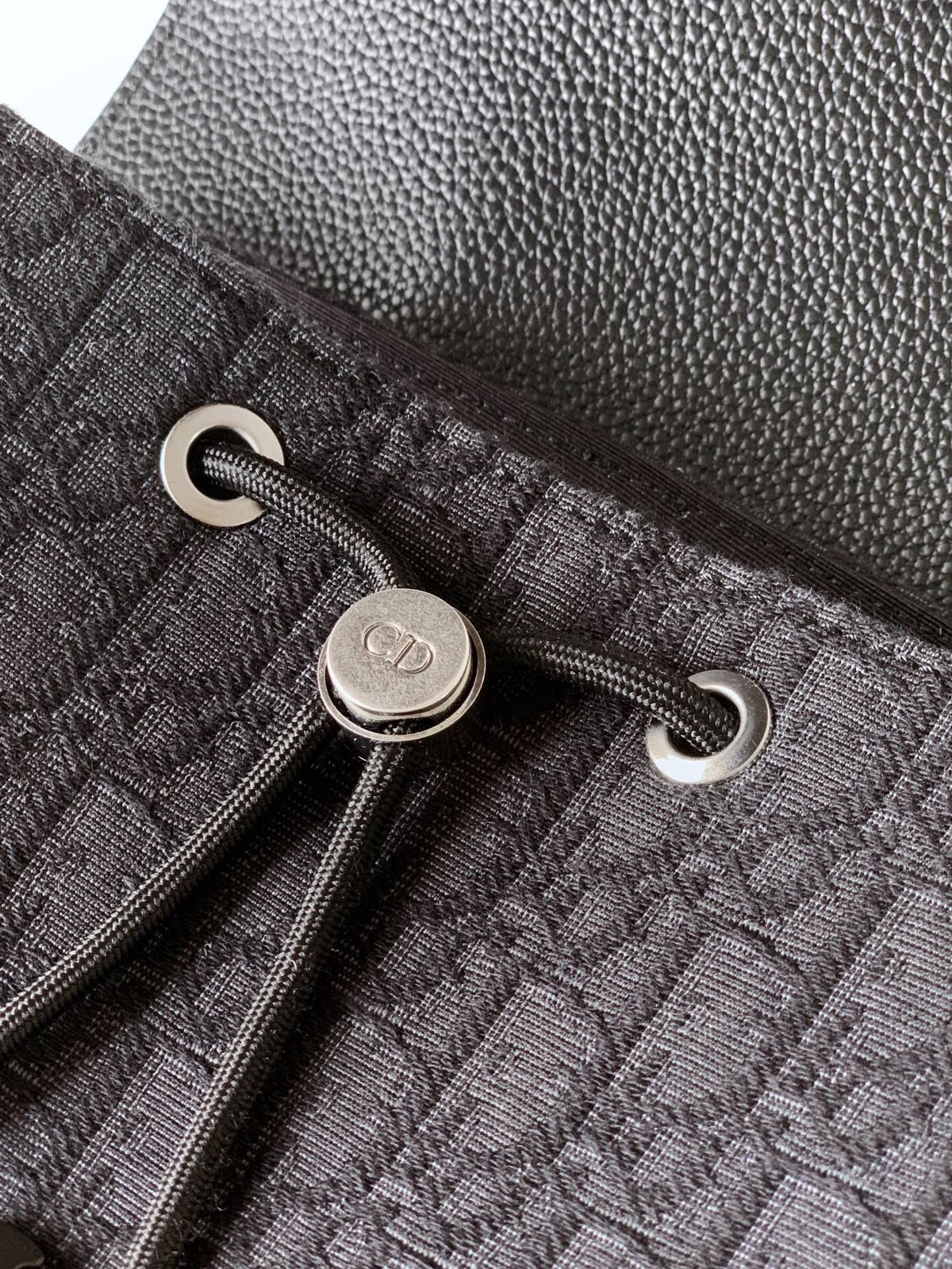 The Heritage Saddle Flap Backpack features a sleek, original design that accentuates your saddle style. Crafted from black Oblique printed fabric, accented with tonal grained calf leather details for added style. A spacious compartment under the saddle