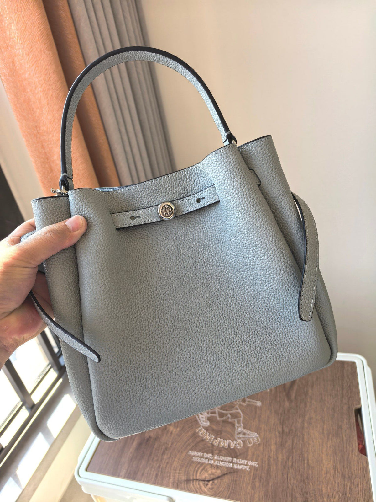 Toryburch's brand new drawstring shopping tote bag with serial number 923 ROMY is a portable crossbody bucket bag made of delicate and thick cowhide material with a soft waist contour. It is the ultimate daily handbag with light weight and spacious interi