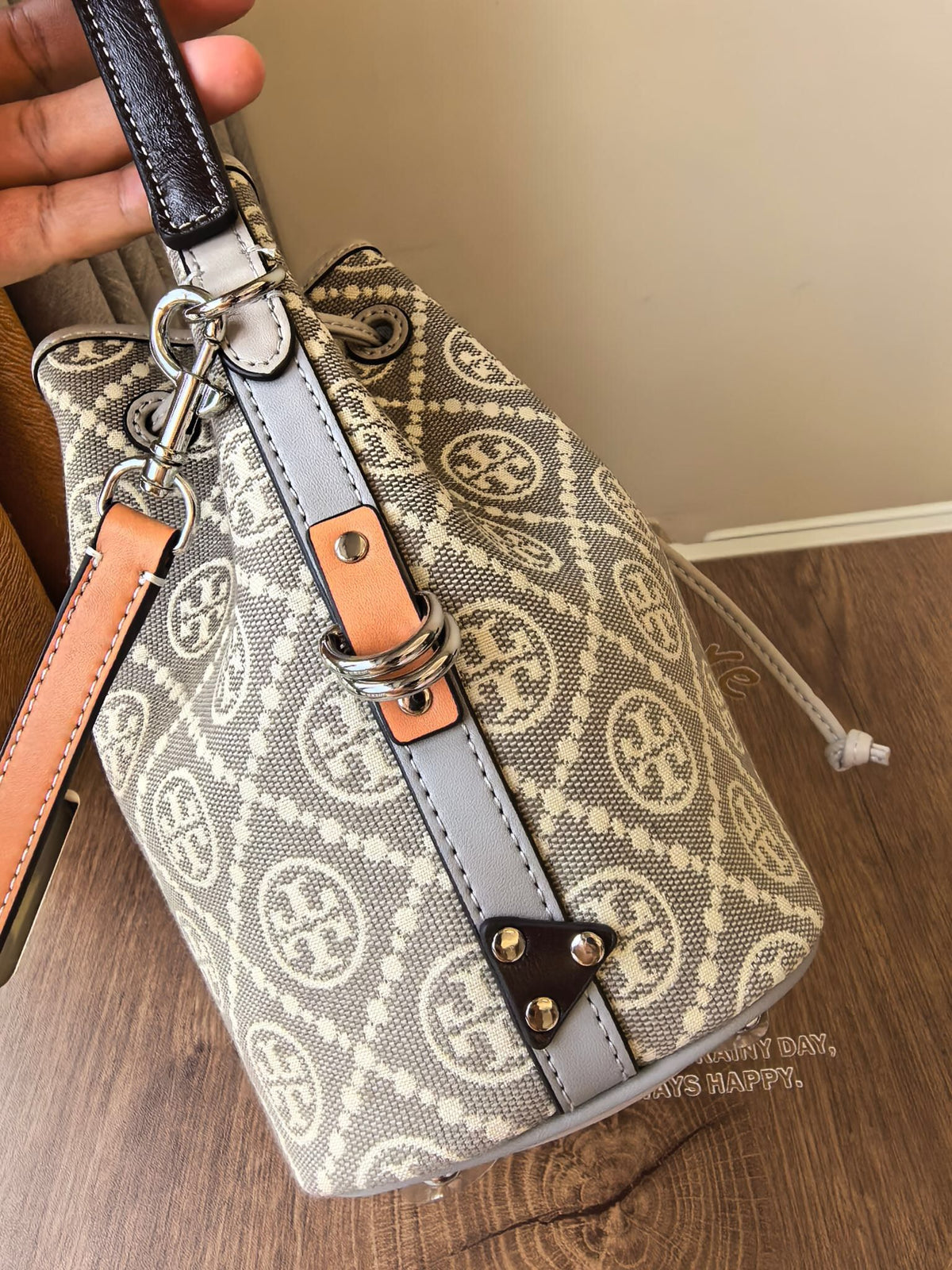 ToryBurch's new 1615A vintage water bucket bag features a classic TMonogram pattern fused with jacquard fabric, creating a charming and timeless style. This bucket bag is adorned with delicate leather trim, a top handle, and a detachable diagonal strap