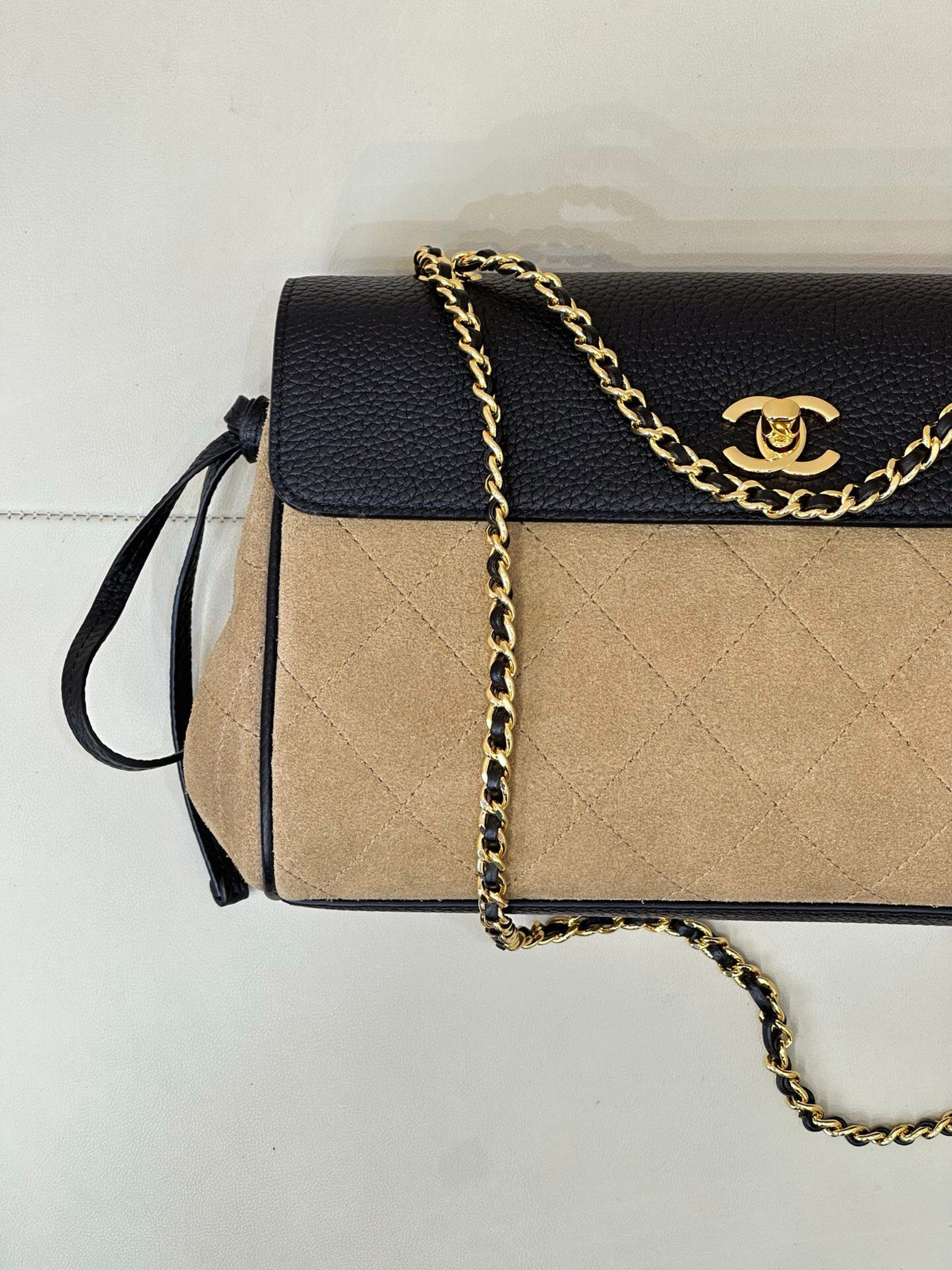 The main body of the apricot bag is made of fine khaki suede. The surface layer has even and soft fluff, with a matte matte texture. It has a retro and old atmosphere. The upper cover is spliced with black grained cowhide. The collision of soft and