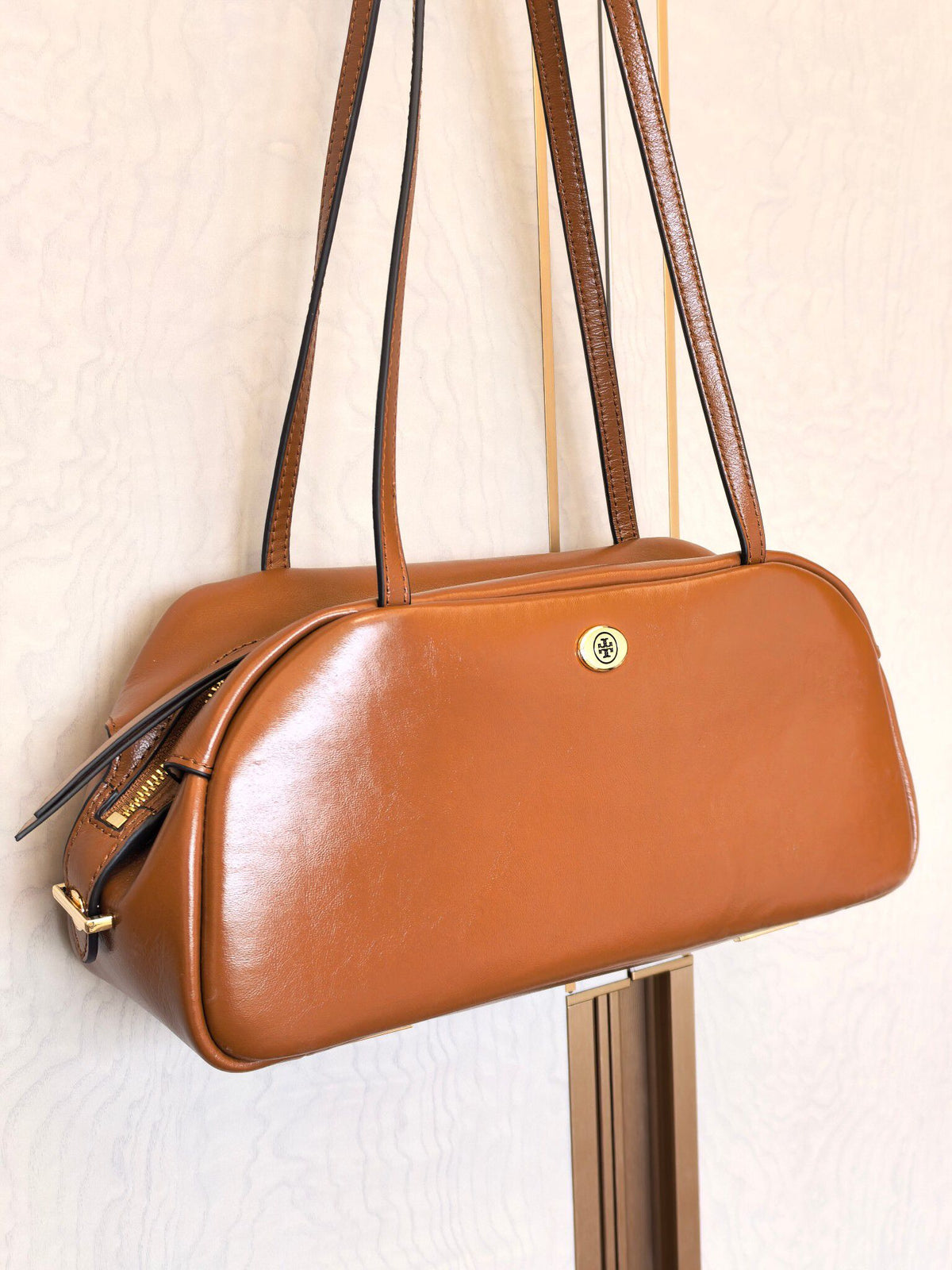 The new TORY BURCH ROBINSON SATCHEL bowling bag is made of oil wax cowhide material, which has a delicate, durable, simple and atmospheric feel. The front brand metal logo is highly recognizable and durable. The bag has a round shape and a large capacity