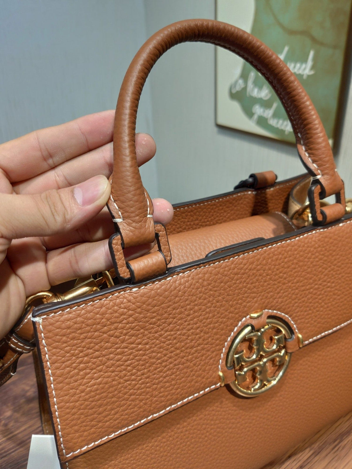 TORY BURCH's classic Miller handbag features lychee patterned cowhide and adjustable length woven leather diagonal straps, showcasing a variety of fashionable styles. The flip cover is equipped with magnetic snap fasteners