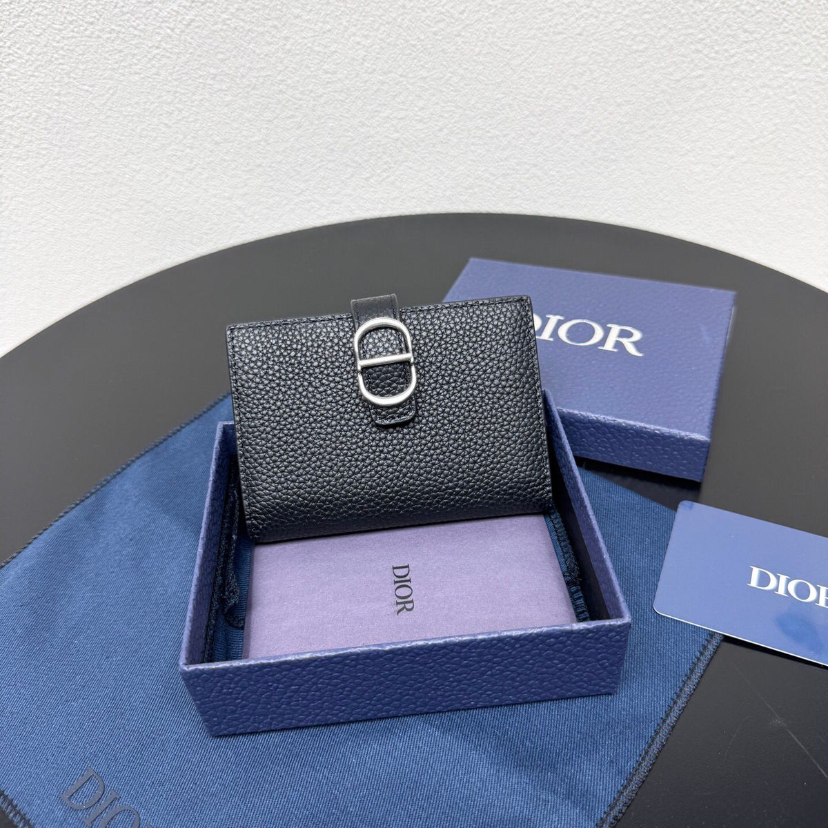 This vertical bifold card holder is elegant and practical. It is crafted from grained cow leather. It is decorated with the CD logo on the front. It has three card slots on each side and two receipt pockets. It is exquisite and elegant. It can be easily