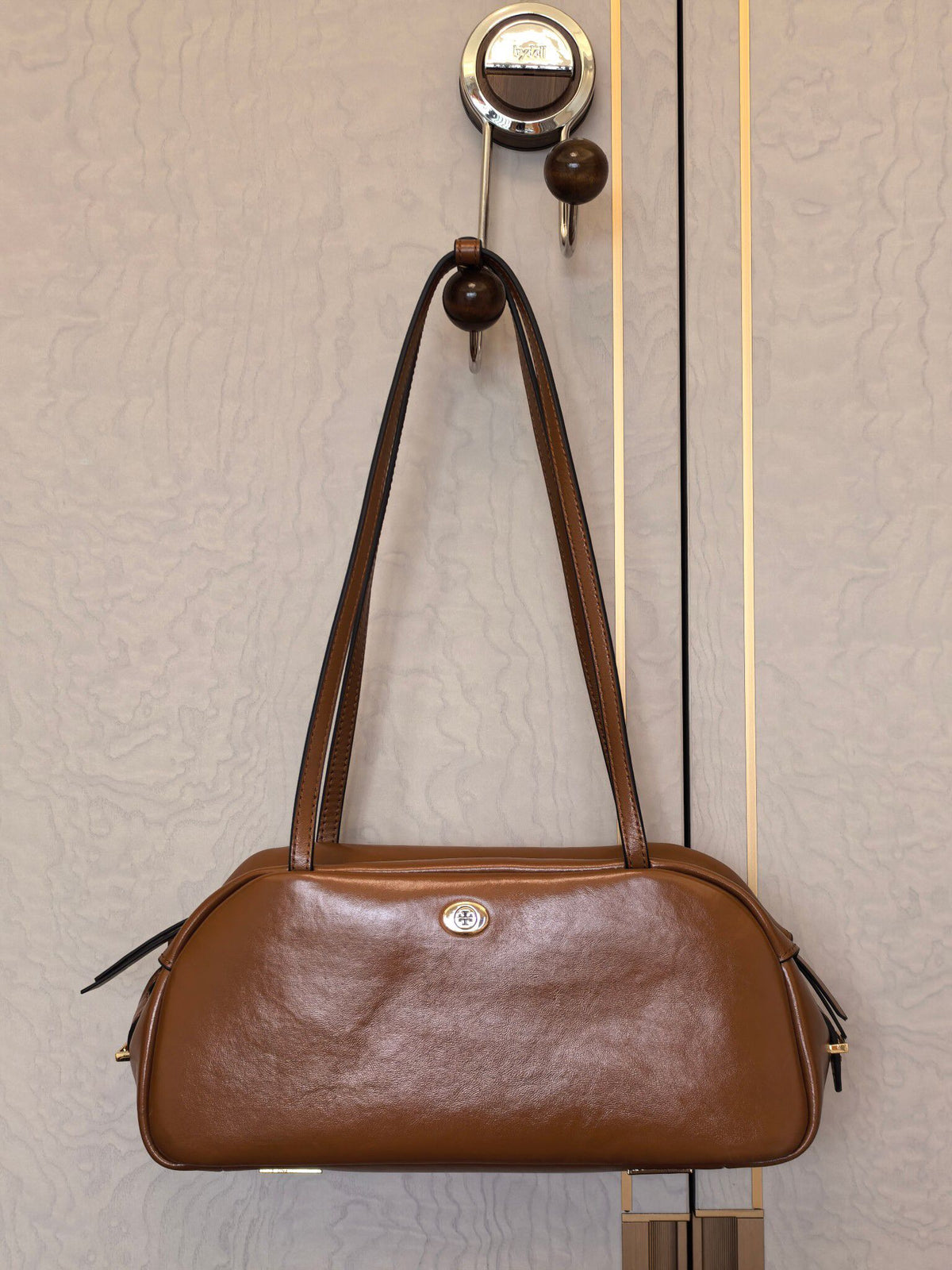 The new TORY BURCH ROBINSON SATCHEL bowling bag is made of oil wax cowhide material, which has a delicate, durable, simple and atmospheric feel. The front brand metal logo is highly recognizable and durable. The bag has a round shape and a large capacity