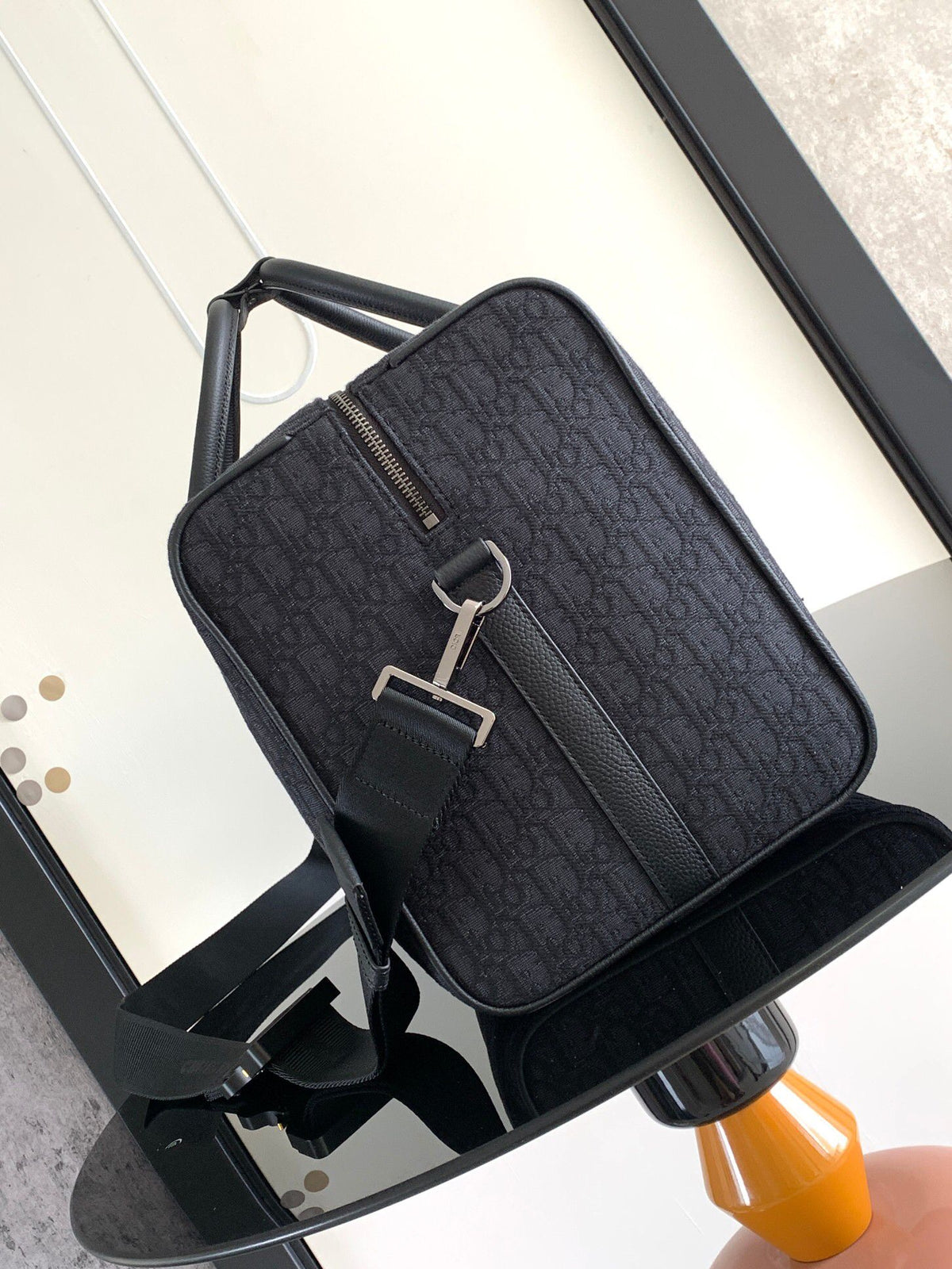 This Dio Lingot 50 handbag is new this season. Practical and elegant, unique. Crafted from black Oblique jacquard fabric. With black grained calfskin leather details to enhance the style. Decorated with DIO logo on the front. Zippered compartment with