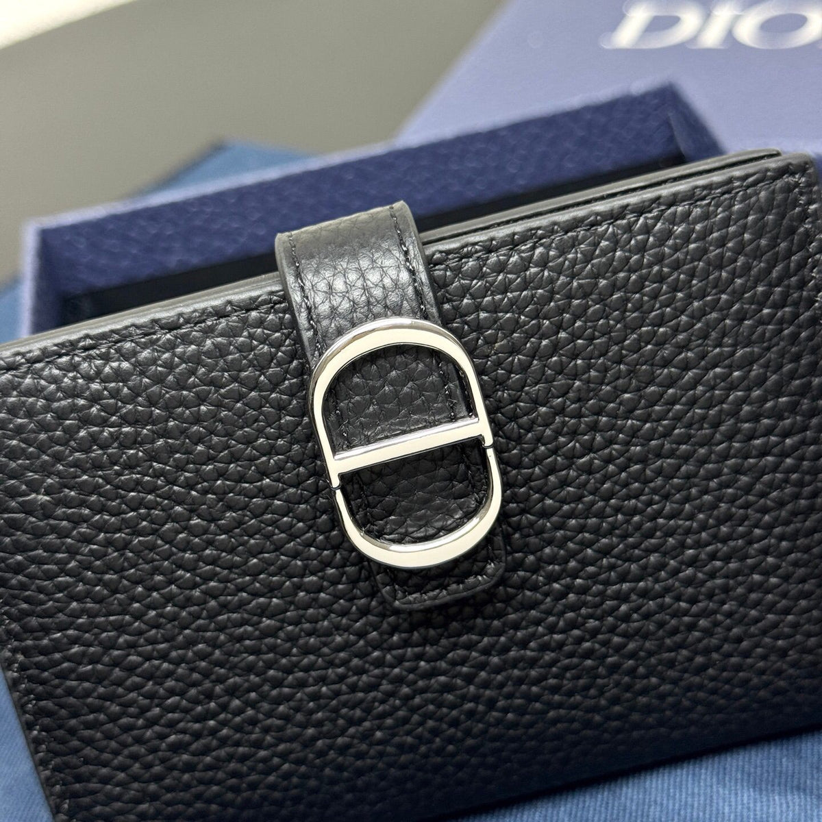 This vertical bifold card holder is elegant and practical. It is crafted from grained cow leather. It is decorated with the CD logo on the front. It has three card slots on each side and two receipt pockets. It is exquisite and elegant. It can be easily