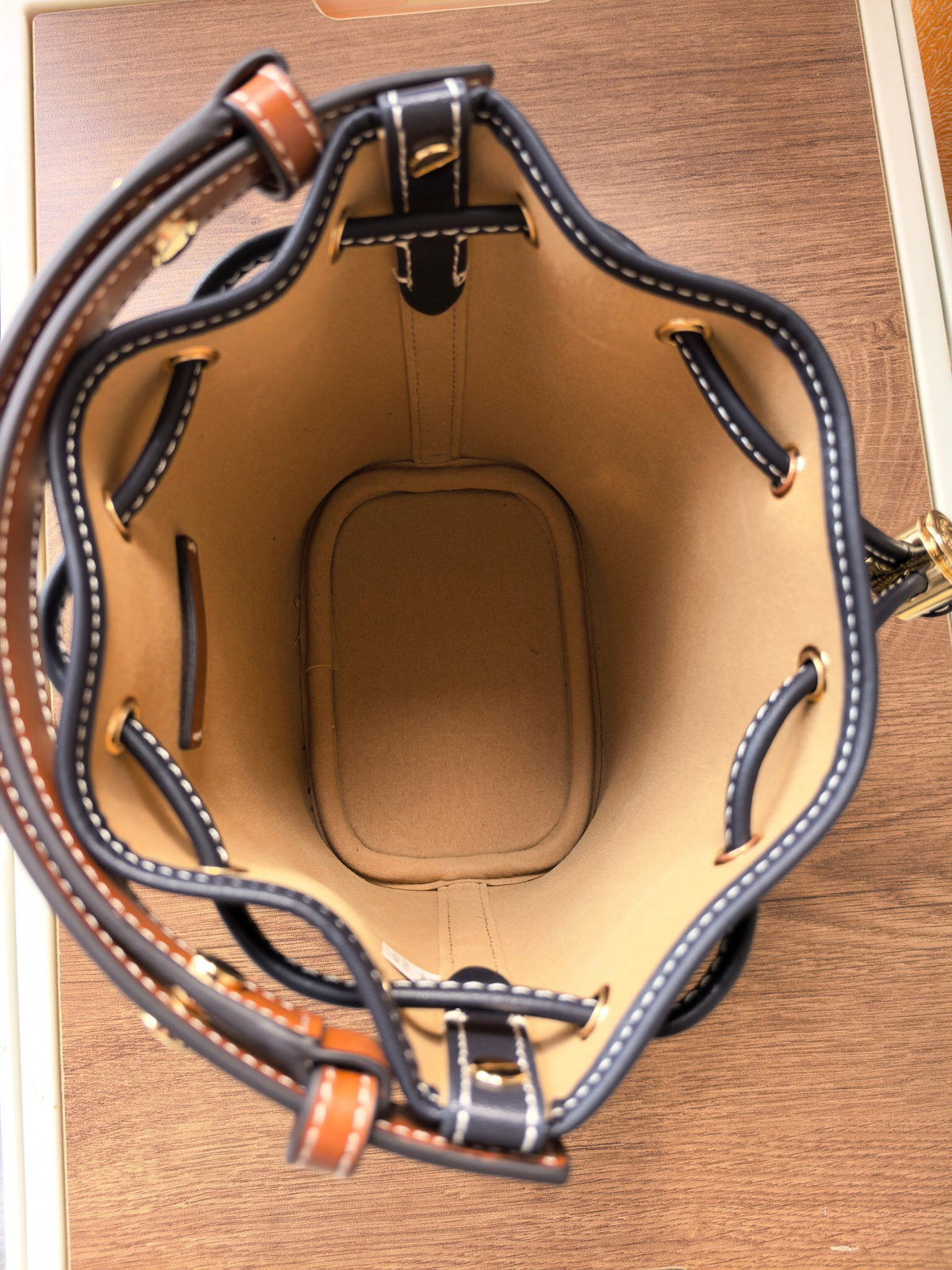 ToryBurch's new 1616A vintage water bucket bag features a classic TMonogram pattern fused with jacquard fabric, creating a charming and timeless style. This mini water bucket bag is adorned with delicate leather trim, a top handle, and a detachable diagon