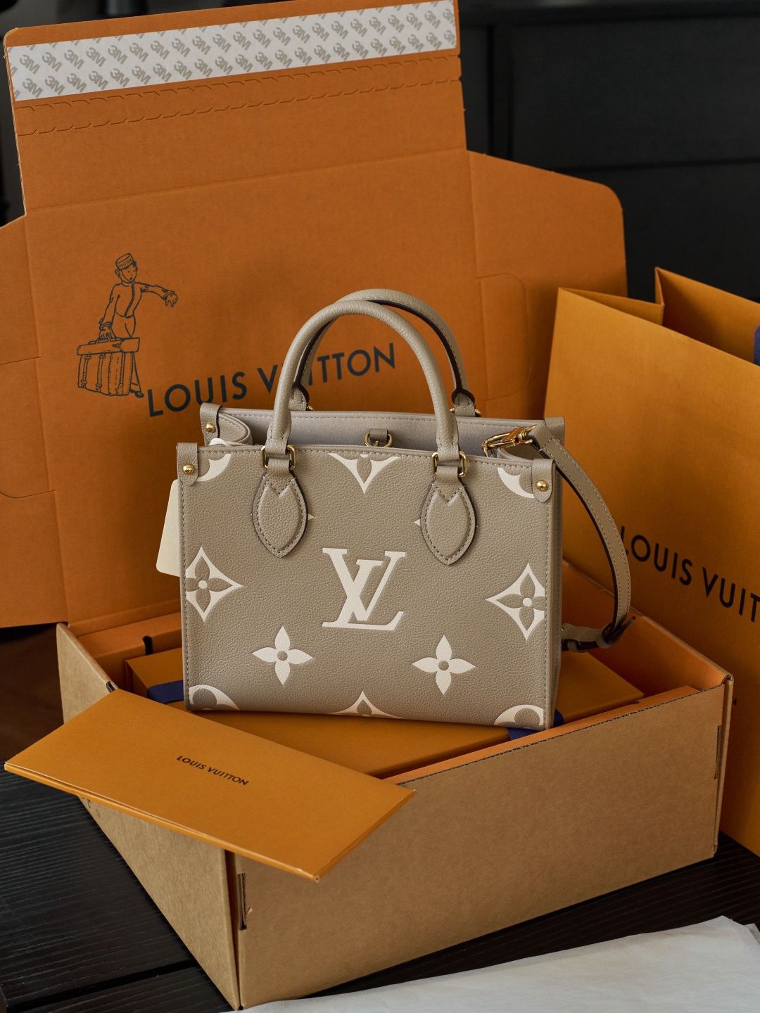 ONTHEGO Small Handbag M45779 This OnTheGo Small Tote Bag draws inspiration from the Sac Plat handbag, which was born in 1968, and incorporates Monogram Empreinte leather with Medium Bicolor Monogram embossing for a slightly smaller size. The original