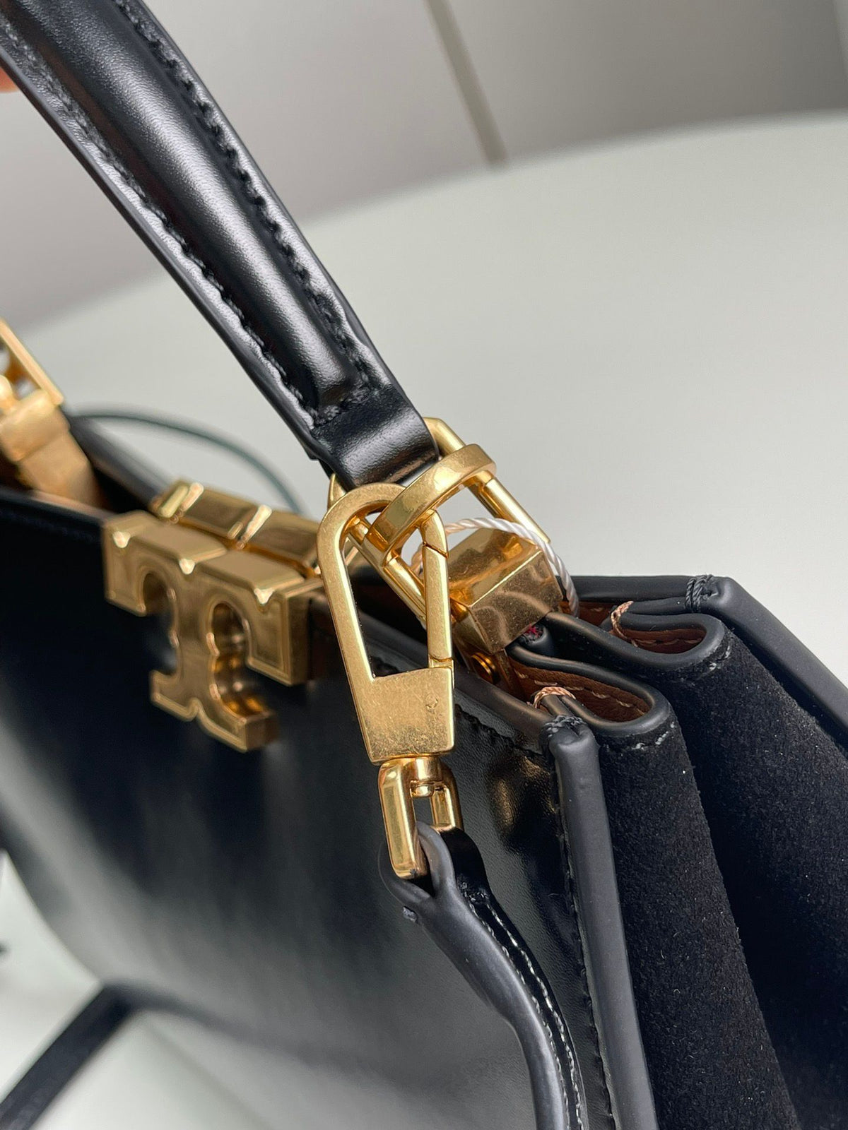 Number 086, TORY BURCH. New Eleanor leather handbag with exquisite suede trim. The bag has a clean and crisp body, and the iconic double T logo is three-dimensional and eye-catching. Exquisite craftsmanship. It can be lifted with a handle or removed