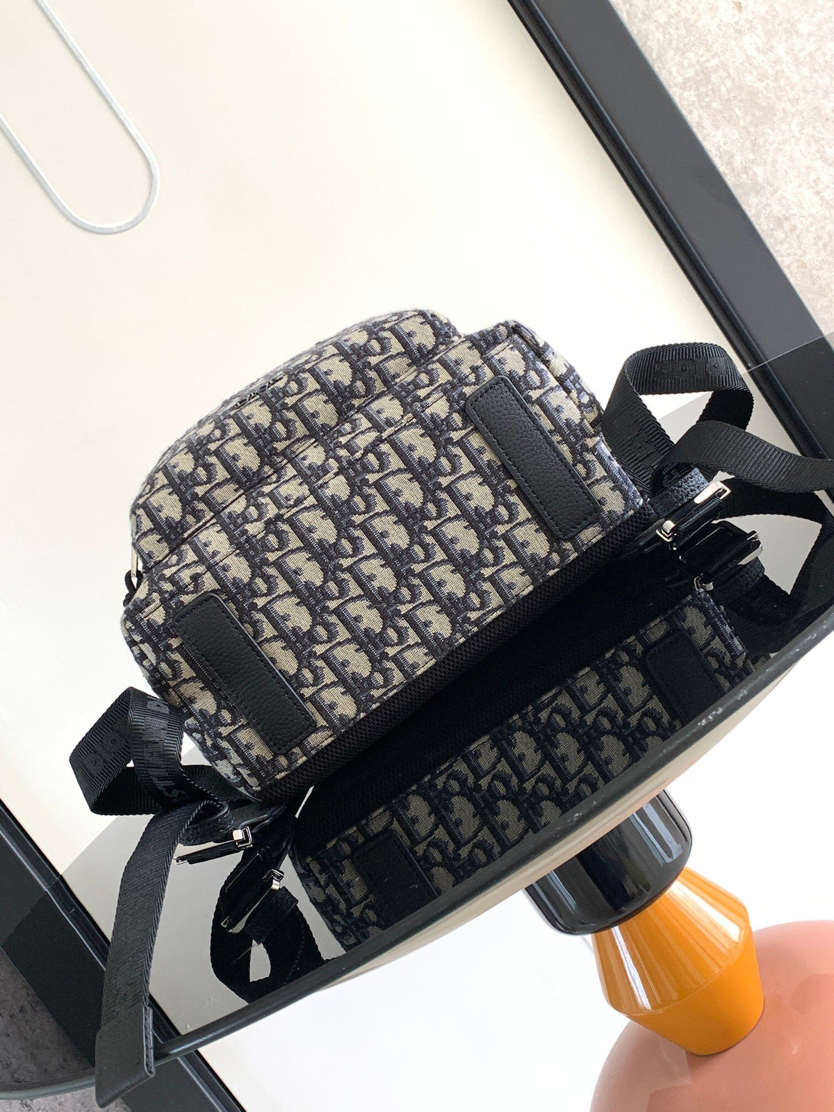 Under the small black lettering. This Rider backpack has a simple silhouette. The classic collegiate style is full of energy. Inspired by the Dior men's collection. Reinterpreted in beige and blue jacquard fabrics. Oblique print throughout. Continuing