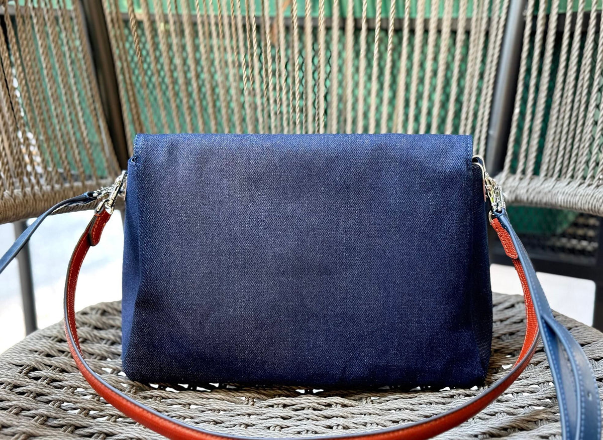 Denim TORY BURCH CHARLE DRNIM SHOULDER BAG denim underarm bag with deep blue denim and contrasting caviar patterned shoulder straps, simple yet textured. The front double T metal logo is highly recognizable, and the underarm back or single shoulder crossb