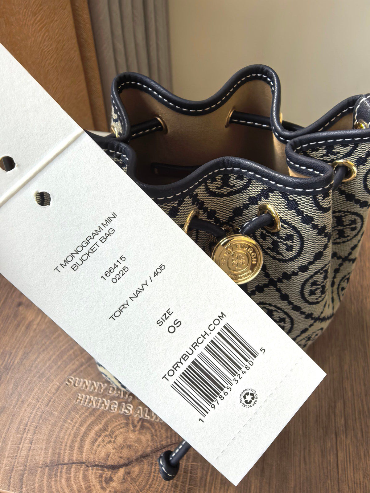 ToryBurch's new 1616A vintage water bucket bag features a classic TMonogram pattern fused with jacquard fabric, creating a charming and timeless style. This mini water bucket bag is adorned with delicate leather trim, a top handle, and a detachable diagon
