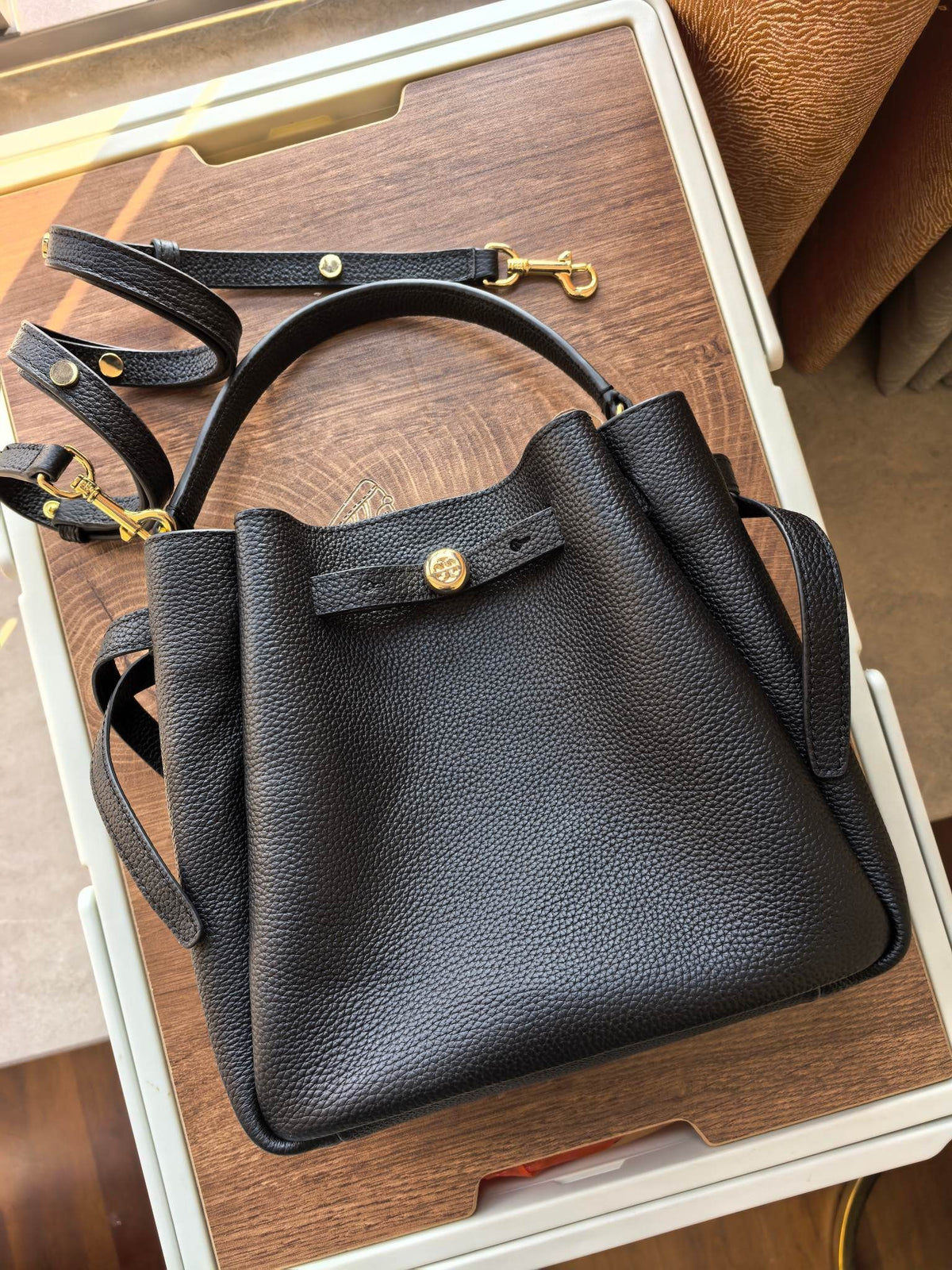 Toryburch's brand new drawstring shopping tote bag with serial number 923 ROMY is a portable crossbody bucket bag made of delicate and thick cowhide material with a soft waist contour. It is the ultimate daily handbag with light weight and spacious interi