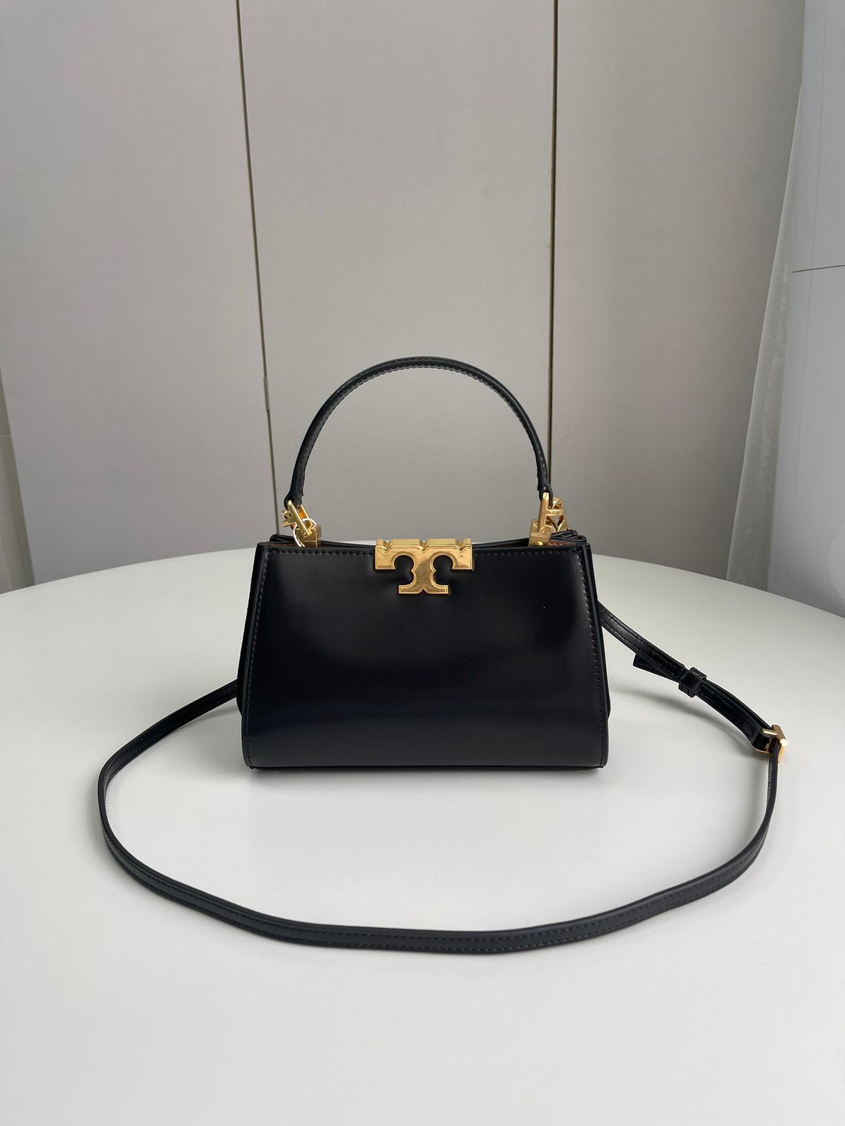Number 086, TORY BURCH. New Eleanor leather handbag with exquisite suede trim. The bag has a clean and crisp body, and the iconic double T logo is three-dimensional and eye-catching. Exquisite craftsmanship. It can be lifted with a handle or removed