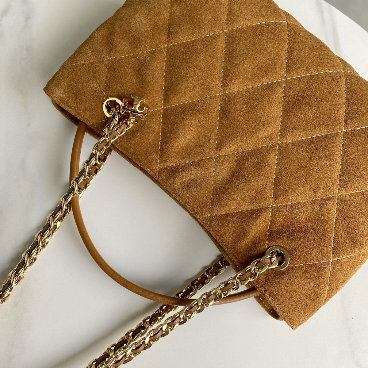 The TB new Fleming series is refreshed with a lightweight and slender quilted diamond grid pattern. This small handbag is crafted from soft leather and features a magnetic snap button with two pockets for easy storage. It can easily accommodate a tablet