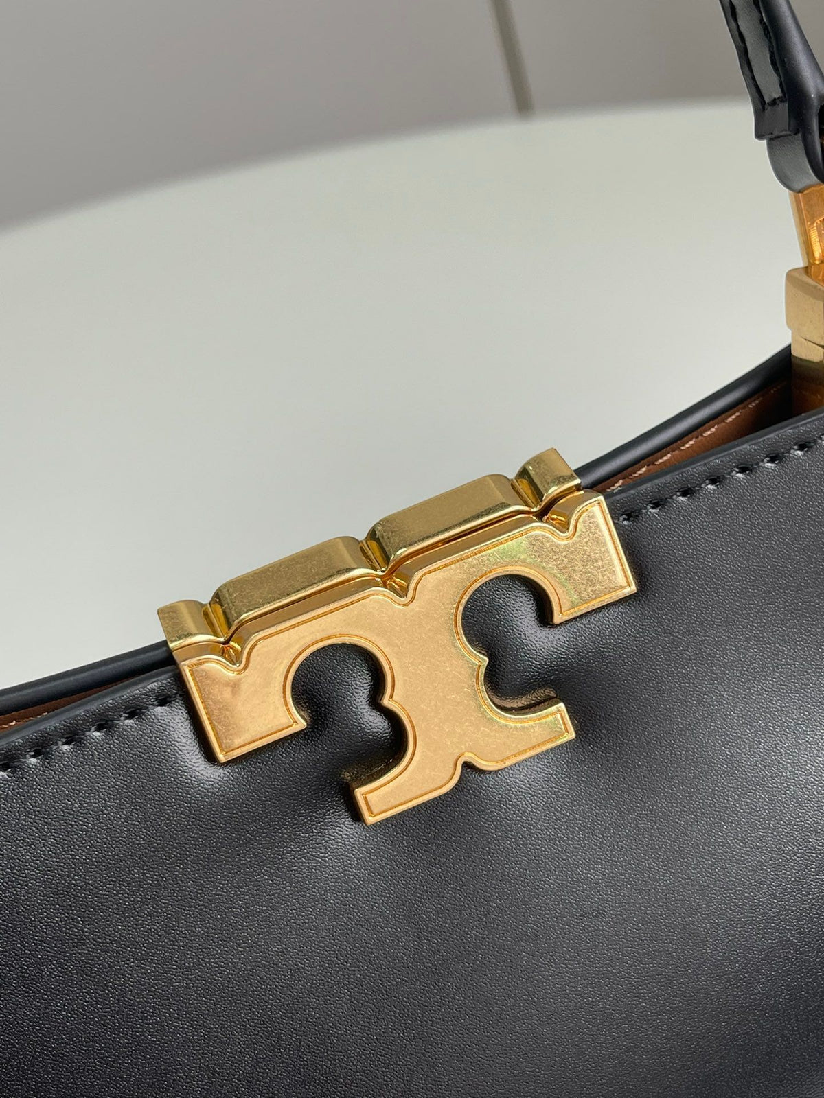 Number 086, TORY BURCH. New Eleanor leather handbag with exquisite suede trim. The bag has a clean and crisp body, and the iconic double T logo is three-dimensional and eye-catching. Exquisite craftsmanship. It can be lifted with a handle or removed