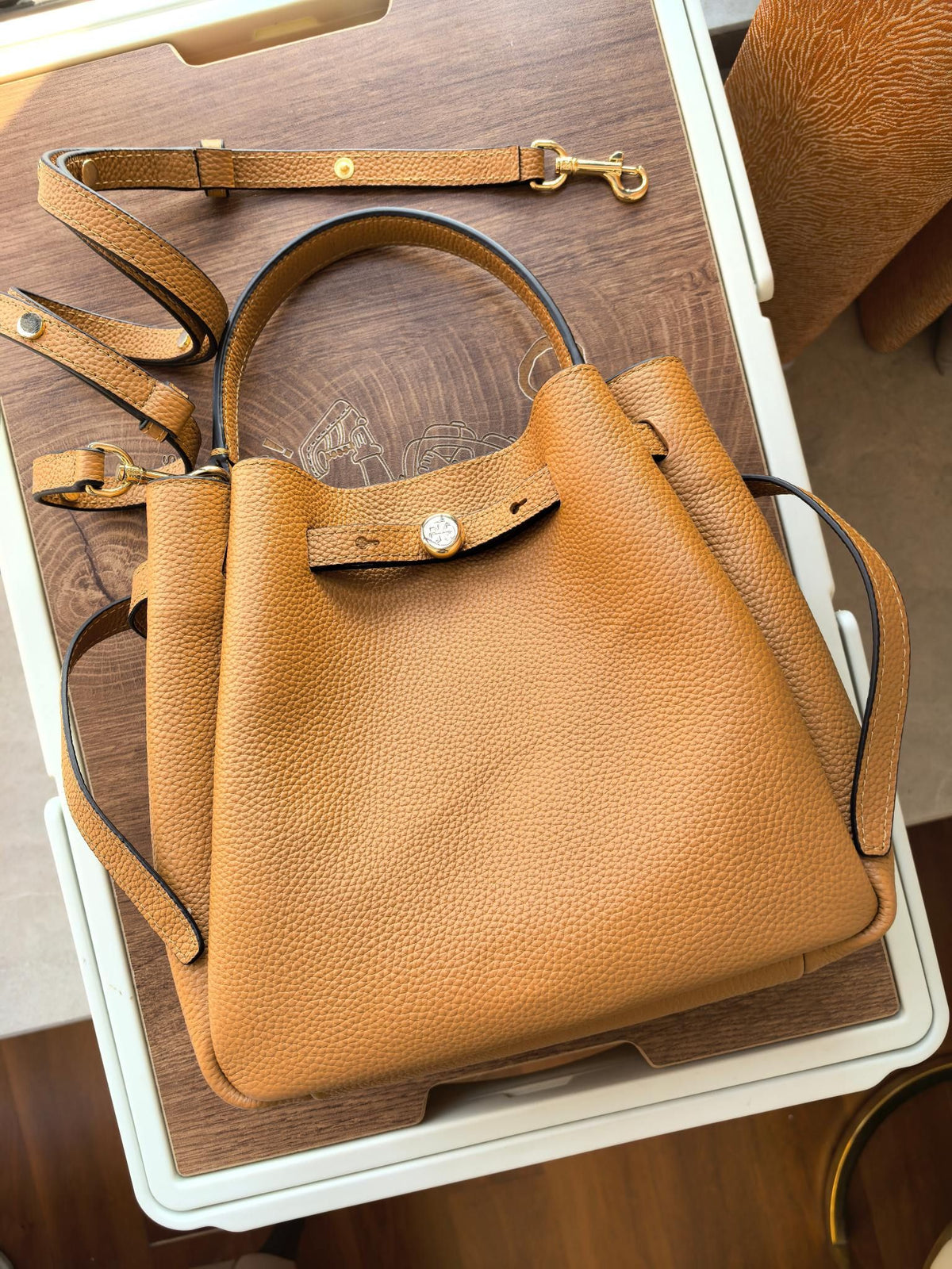 Toryburch's brand new drawstring shopping tote bag with serial number 923 ROMY is a portable crossbody bucket bag made of delicate and thick cowhide material with a soft waist contour. It is the ultimate daily handbag with light weight and spacious interi