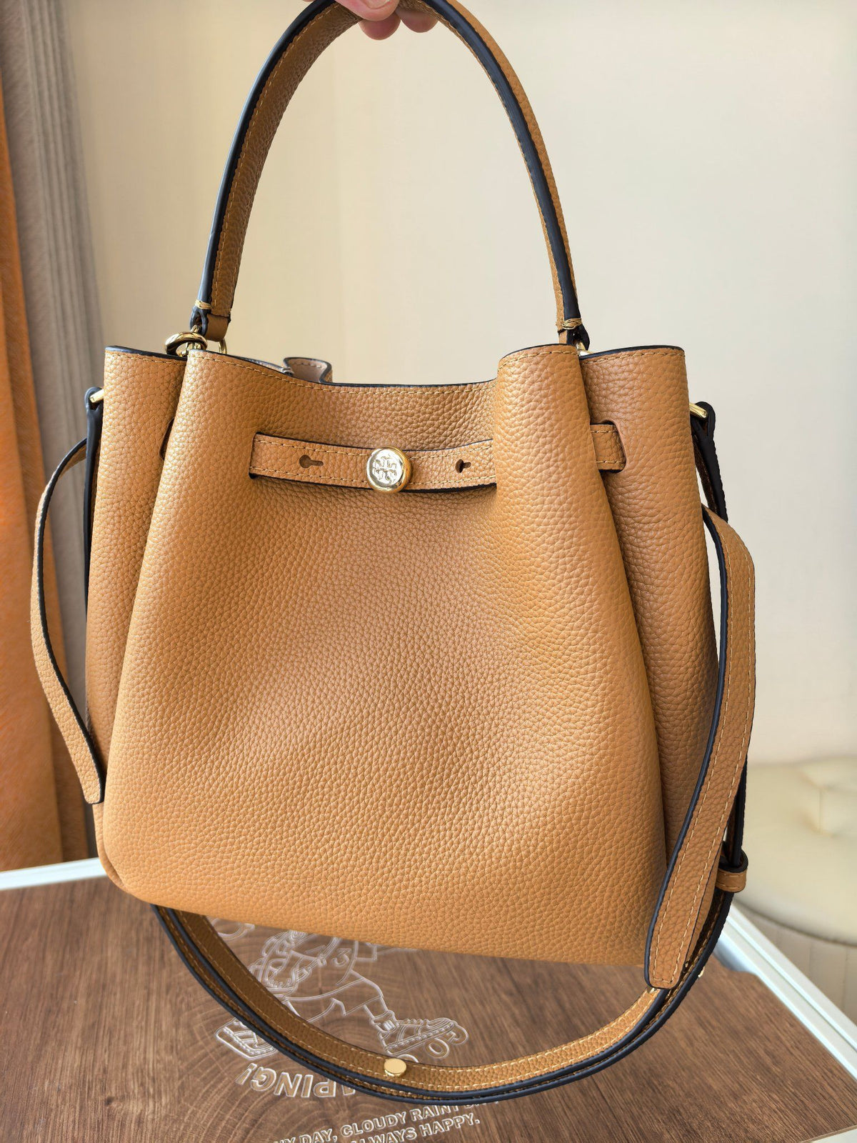 Toryburch's brand new drawstring shopping tote bag with serial number 923 ROMY is a portable crossbody bucket bag made of delicate and thick cowhide material with a soft waist contour. It is the ultimate daily handbag with light weight and spacious interi